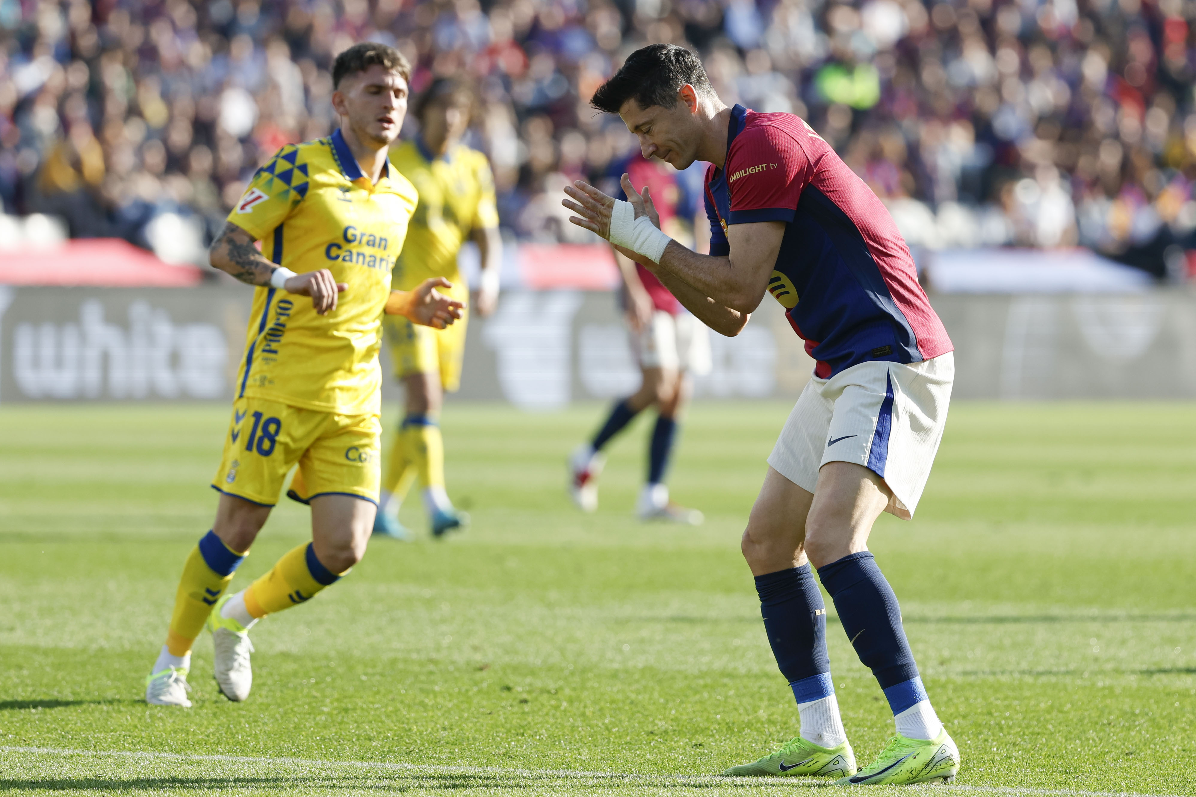 Barcelona's Robert Lewandowski, right, reacts after missing a chance to score a goal against Las Palmas during a Spanish La Liga soccer match at the Lluis Companys Olympic Stadium in Barcelona, Spain, Saturday Nov. 30, 2024.