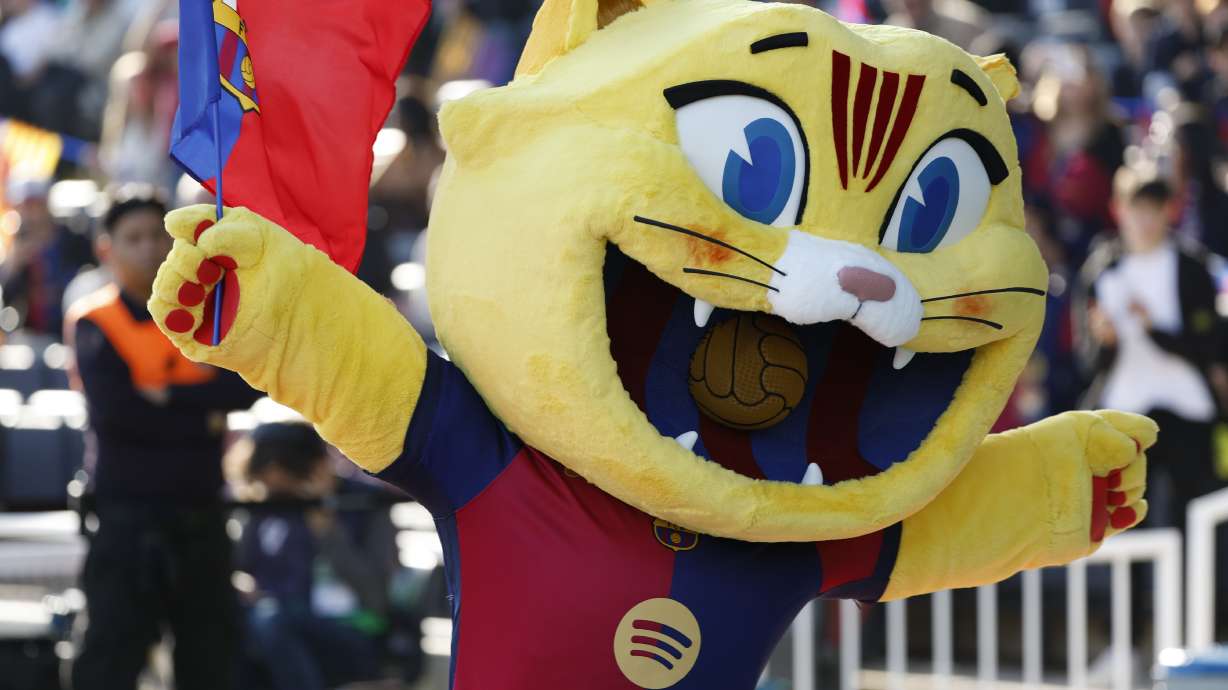 Barcelona's mascot Cat waves a flag prior to a Spanish La Liga soccer match against Las Palmas at the Lluis Companys Olympic Stadium in Barcelona, Spain, Saturday Nov. 30, 2024.