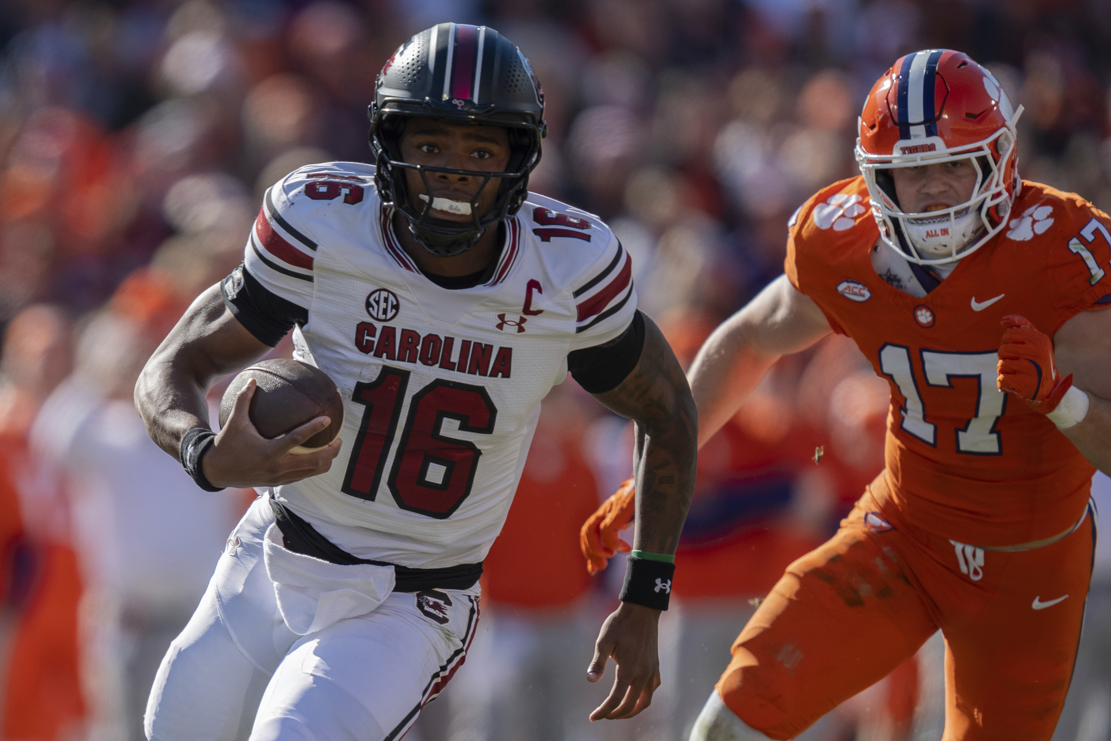 South Carolina quarterback LaNorris Sellers (16) runs with the ball while pursued by Clemson linebacker Wade Woodaz (17) in the first half of an NCAA college football game Saturday, Nov. 30, 2024, in Clemson, S.C. 