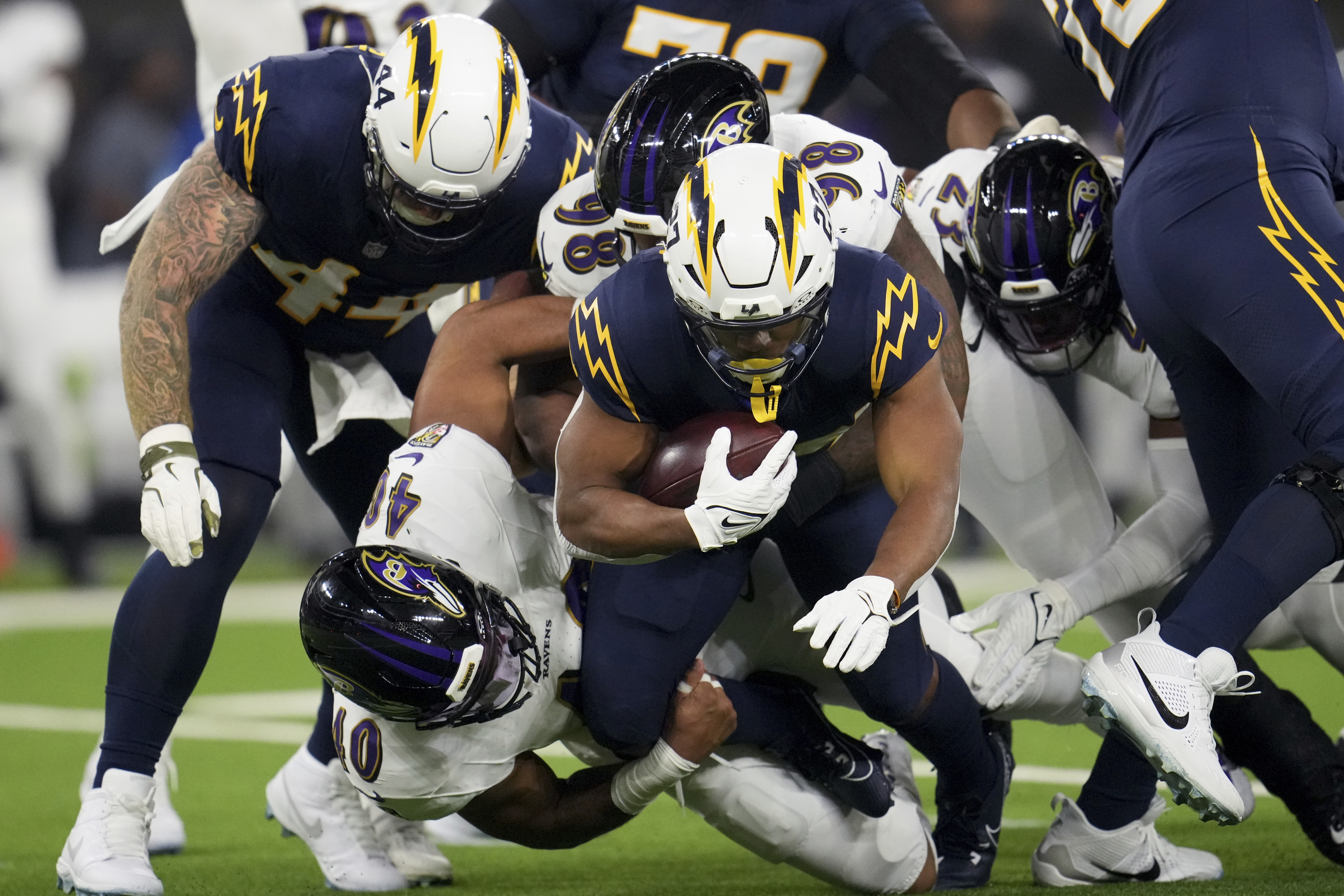 Los Angeles Chargers running back J.K. Dobbins (27) is tackled by Baltimore Ravens linebacker Malik Harrison (40) during the first half of an NFL football game Monday, Nov. 25, 2024, in Inglewood, Calif.