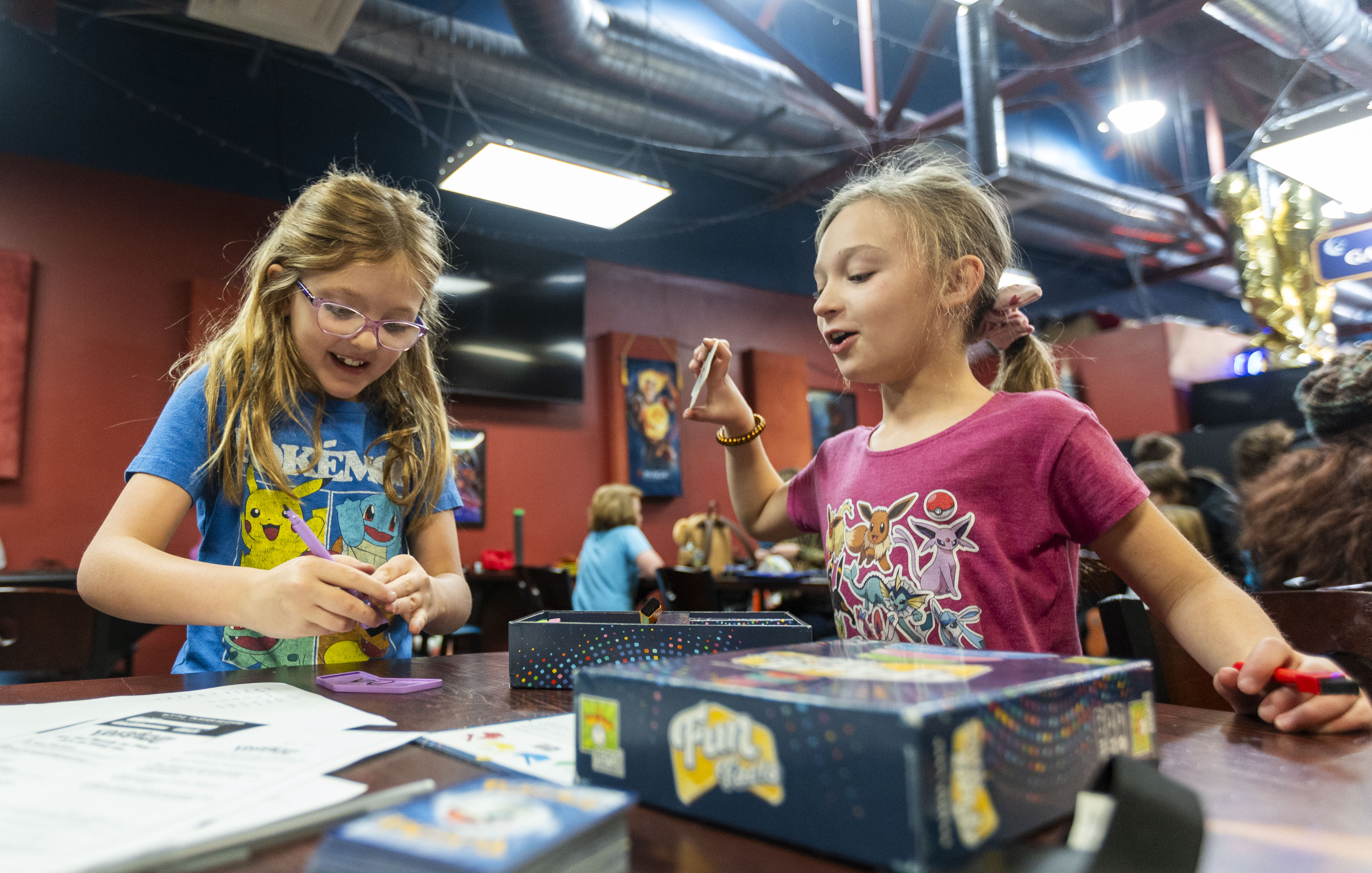 Ellie Howe, left, and Evie Kennington, both 7, laugh while playing a game on Small Business Saturday at Game Night Games, a board and card game hobby store in the Sugar House neighborhood of Salt Lake City, on Saturday.