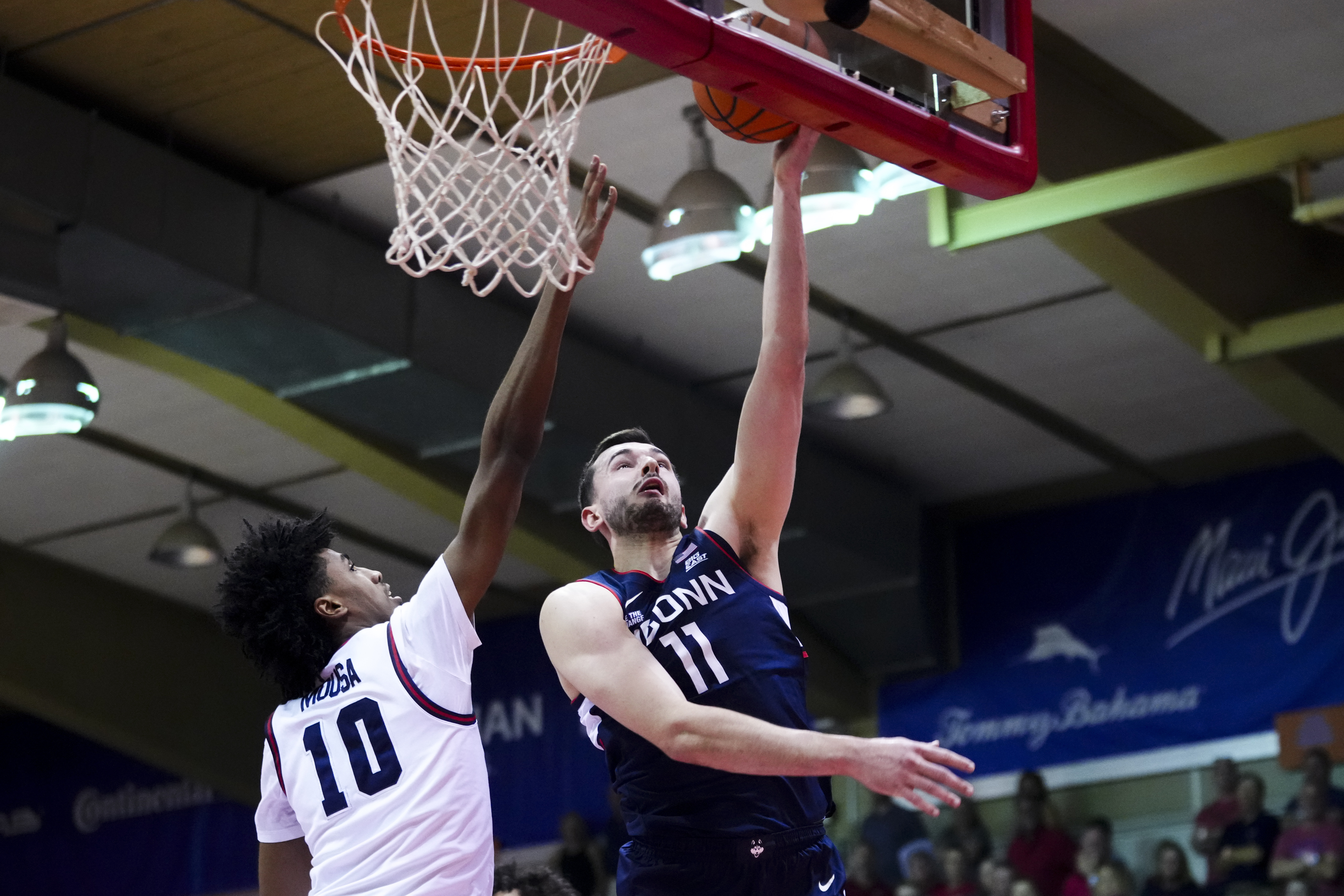 UConn forward Alex Karaban (11) goes to the basket against Dayton guard Hamad Mousa (10) during the first half of an NCAA college basketball game at the Maui Invitational Wednesday, Nov. 27, 2024, in Lahaina, Hawaii.