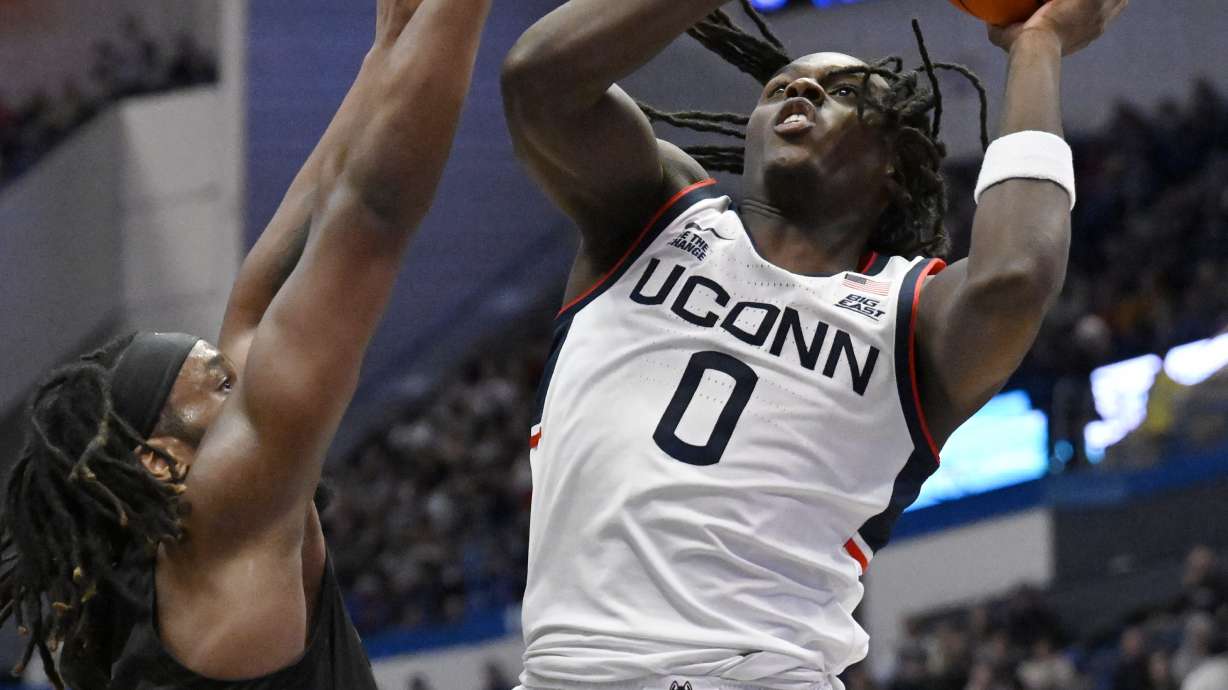 UConn guard Ahmad Nowell (0) goes up to shoot as Maryland-Eastern Shore forward Christopher Flippin, left, defends in the first half of an NCAA college basketball game, Saturday, Nov. 30, 2024, in Hartford, Conn.