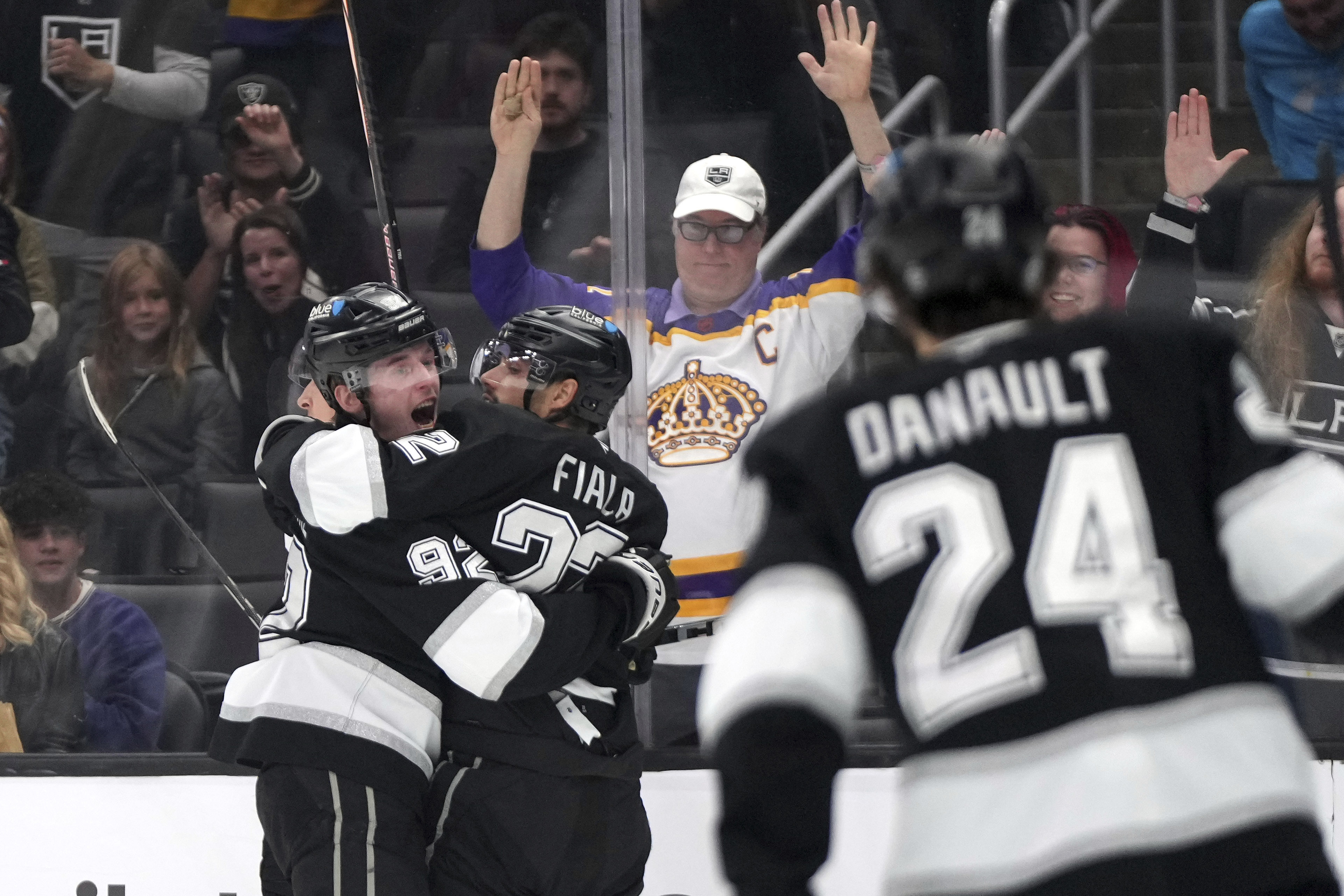 Los Angeles Kings left wing Kevin Fiala, center, celebrates his goal with defenseman Brandt Clarke, left, as center Phillip Danault skates in during the second period of an NHL hockey game against the Ottawa Senators, Saturday, Nov. 30, 2024, in Los Angeles. 