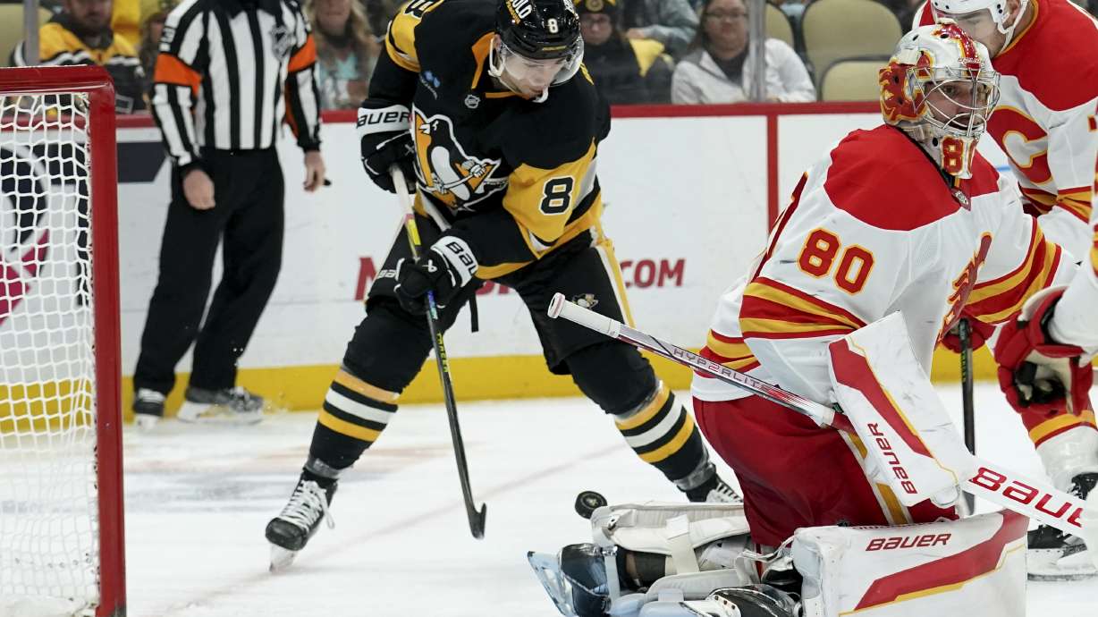 Pittsburgh Penguins' Michael Bunting (8) shoots to score behind Calgary Flames goaltender Dan Vladar (80) during the second period of an NHL hockey game Saturday, Nov. 30, 2024, in Pittsburgh.