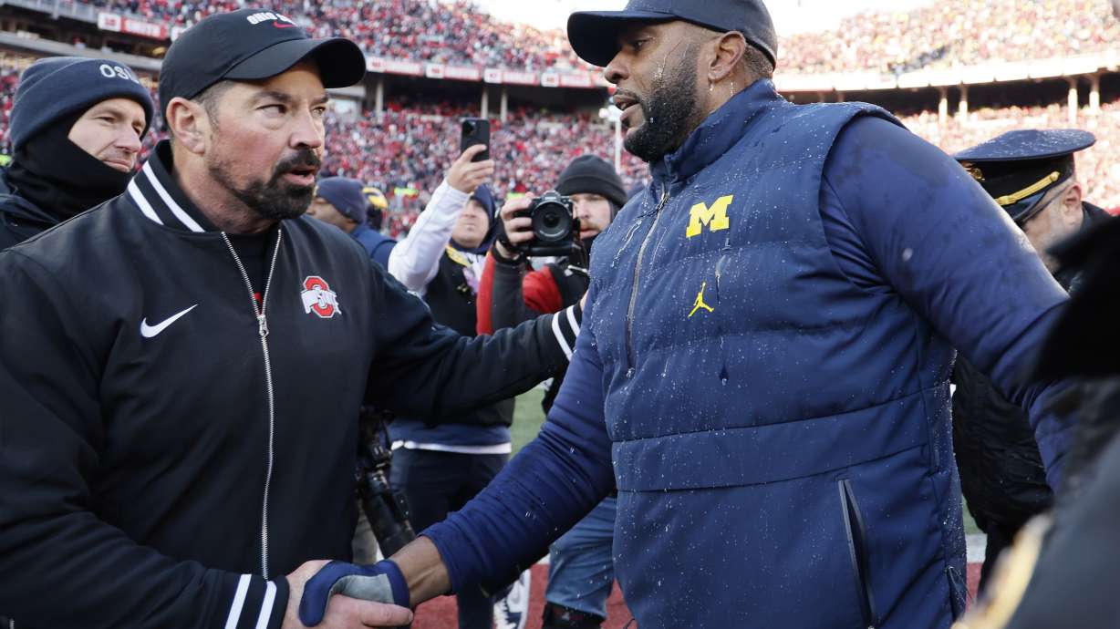 Ohio State head coach Ryan Day, left, and Michigan head coach Sherrone Moore shake hands after an NCAA college football game Saturday, Nov. 30, 2024, in Columbus, Ohio.