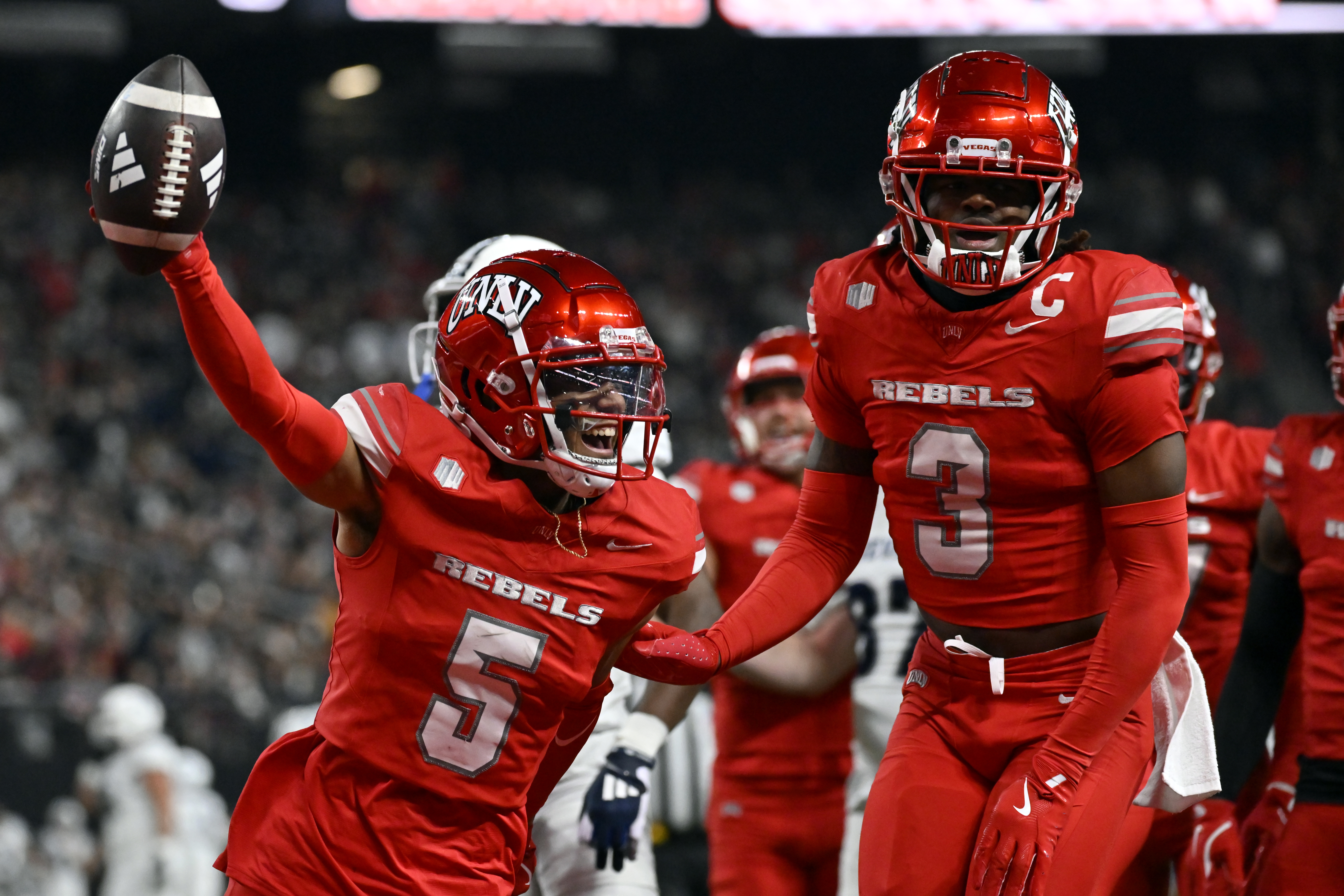UNLV defensive backs Cameron Oliver (5) and Johnathan Baldwin (3) celebrate after Oliver intercepted the ball against Nevada during the first half of an NCAA college football game Saturday, Nov. 30, 2024, in Las Vegas.