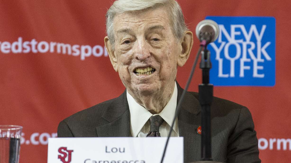 FILE - Former St. John's men's basketball coach Lou Carnesecca smiles during a news conference to announce the hiring of his former player and retired NBA basketball All-Star Chris Mullin, on April 1, 2015, in New York.