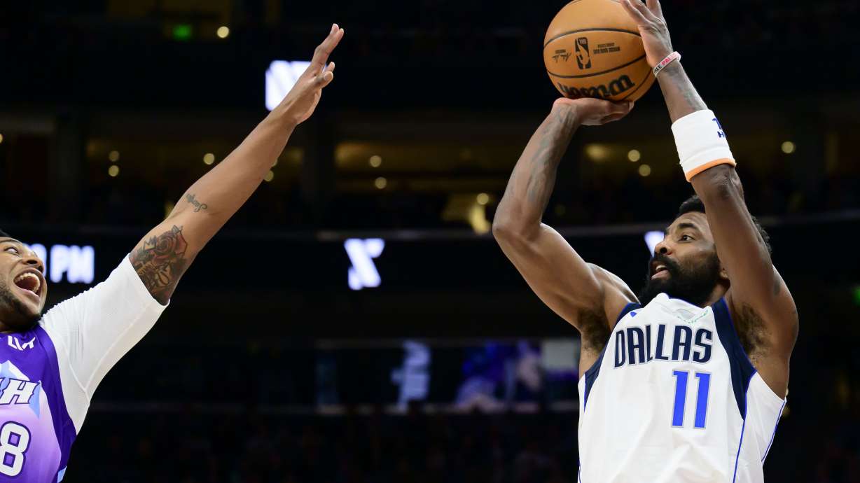 Dallas Mavericks guard Kyrie Irving (11) looks to shoot over Utah Jazz forward Brice Sensabaugh, left, during the first half of an NBA basketball game Saturday, Nov. 30, 2024, in Salt Lake City.