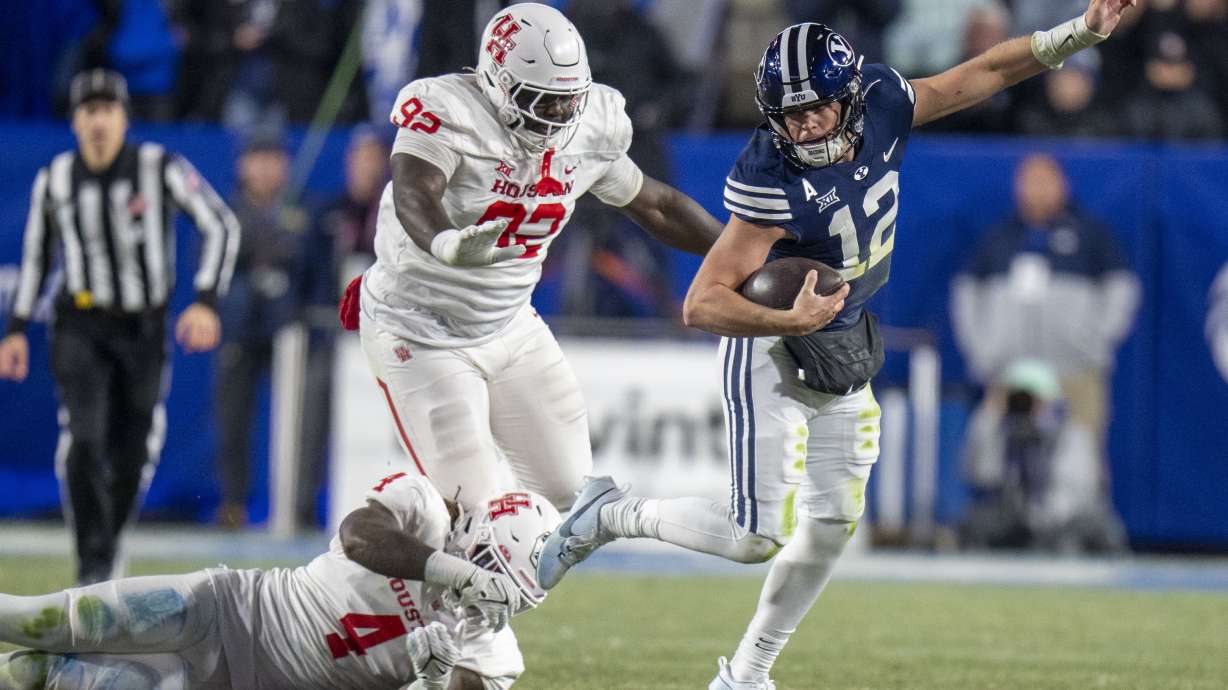 BYU quarterback Jake Retzlaff (12) slips out of the hands of Houston linebacker Brandon Mack (4) as Houston defensive lineman Carlos Allen (92) pursues during the first half of a college football game Saturday, Nov. 30, 2024, in Provo.