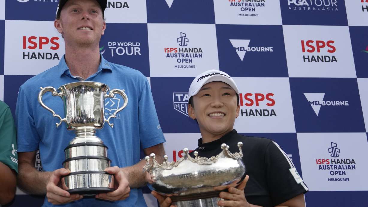 Ryggs Johnston, left, of the United States and Jiyai Shin of Korea hold their trophies after winning the Australian Open golf championship at the Kingston Heath Golf Club in Melbourne, Australia, Sunday, Dec. 1, 2024.