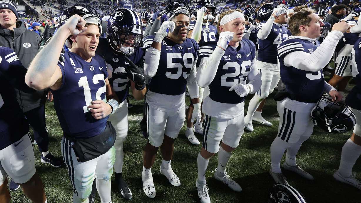 Brigham Young Cougars quarterback Jake Retzlaff (12) and his teammates celebrate their win over the Houston Cougars in Provo on Saturday, Nov. 30, 2024. BYU won 30-18.
