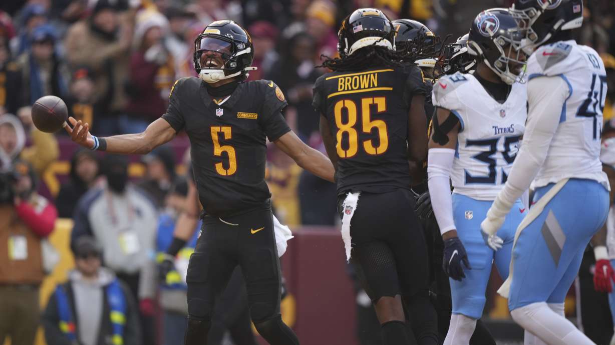 Washington Commanders quarterback Jayden Daniels (5) celebrates his touchdown during the first half of an NFL football game against the Tennessee Titans, Sunday, Dec. 1, 2024, in Landover, Md.