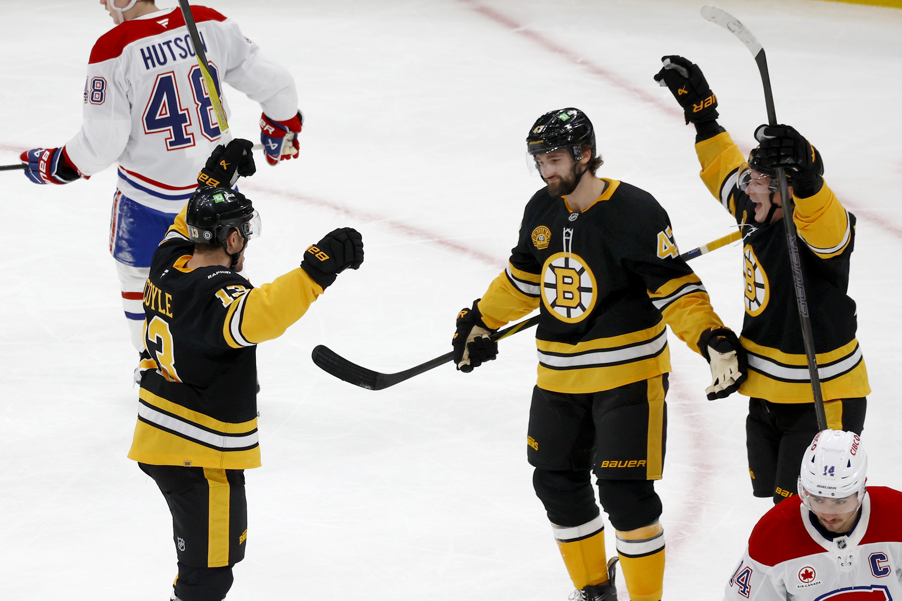 Boston Bruins Charlie Coyle (13) celebrates after a goal with teammates Mark Kastelic (47) and Trent Frederic, top right, as Montreal Canadiens players react during the first period of an NHL hockey game, Sunday, Dec. 1, 2024, in Boston.