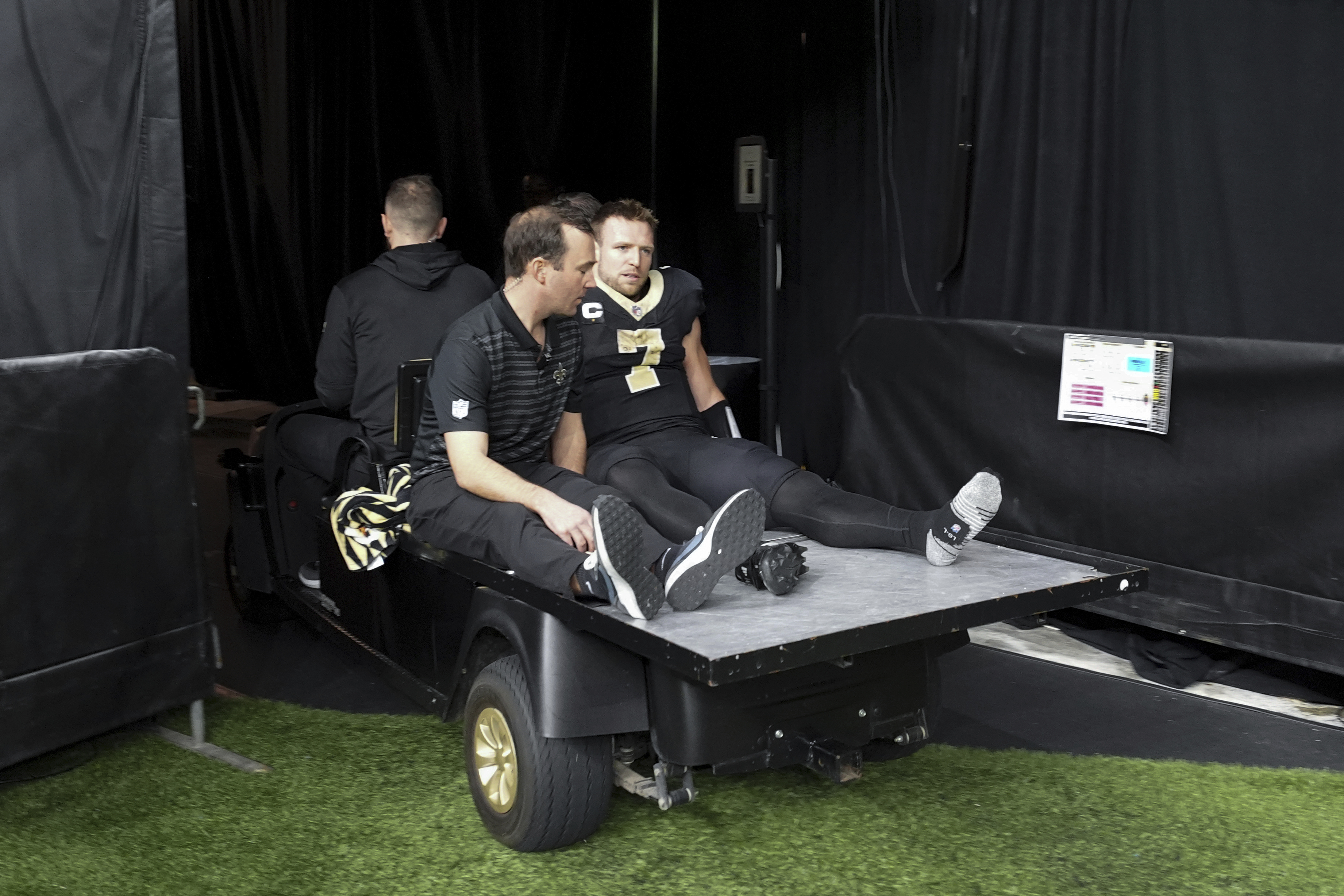 New Orleans Saints tight end Taysom Hill (7) is carted off the field during the second half of an NFL football game against the Los Angeles Rams, Sunday, Dec. 1, 2024, in New Orleans.
