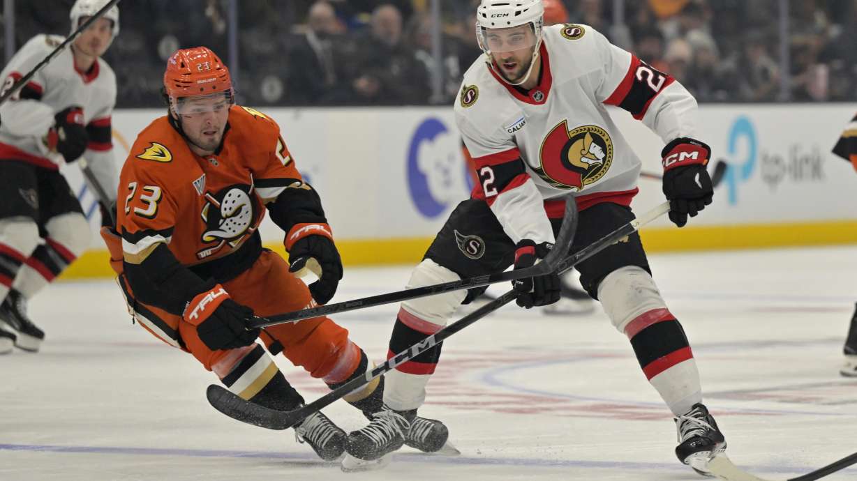 Anaheim Ducks center Mason McTavish (23) and Ottawa Senators right wing Michael Amadio (22) chase down the puck during the first period of an NHL hockey game Sunday, Dec. 1, 2024, in Anaheim, Calif.