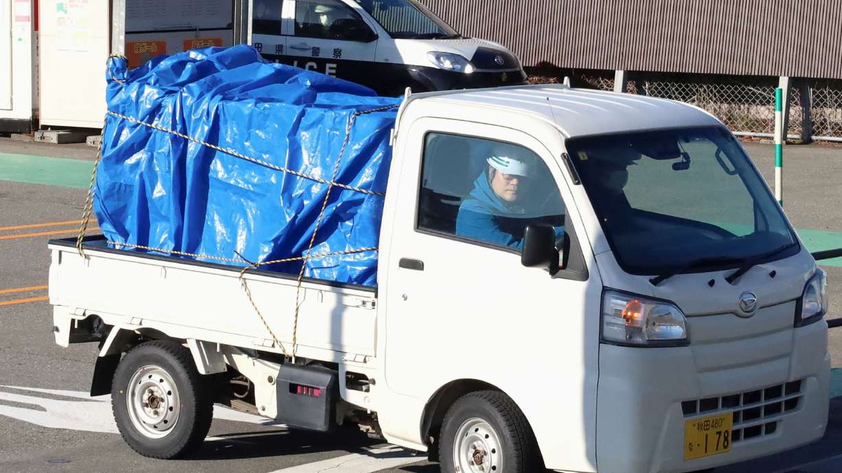 A minitruck carries a bear after it was trapped at a supermarket in Akita, Japan, on Monday.