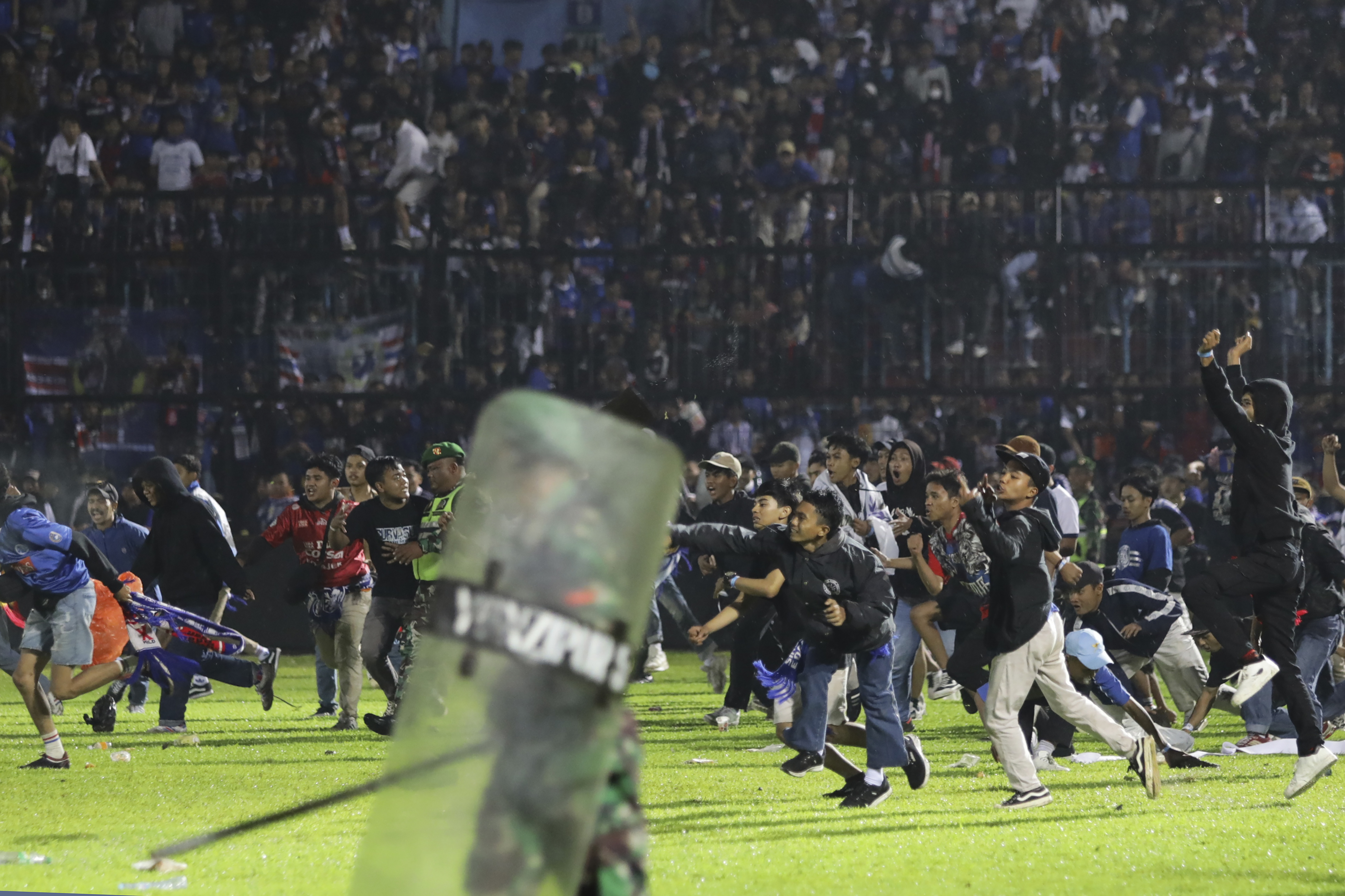 FILE - Soccer fans enter the pitch during a clash between supporters at Kanjuruhan Stadium in Malang, East Java, Indonesia, Saturday, Oct. 1, 2022.