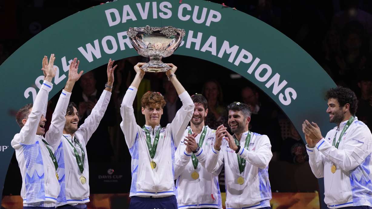 Italy's Jannik Sinner, center, holds the Davis Cup trophy by teammates after the final between Netherlands and Italy at the Martin Carpena Sports Hall in Malaga, southern Spain, as Italy wins its second consecutive Davis Cup title, Sunday, Nov. 24, 2024.