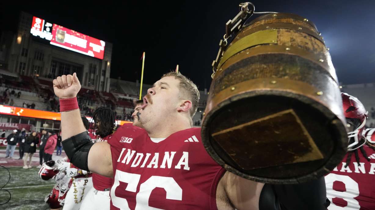 Indiana's Mike Katic celebrates with the Old Oaken Bucket after defeating Purdue in an NCAA college football game, Saturday, Nov. 30, 2024, in Bloomington, Ind.