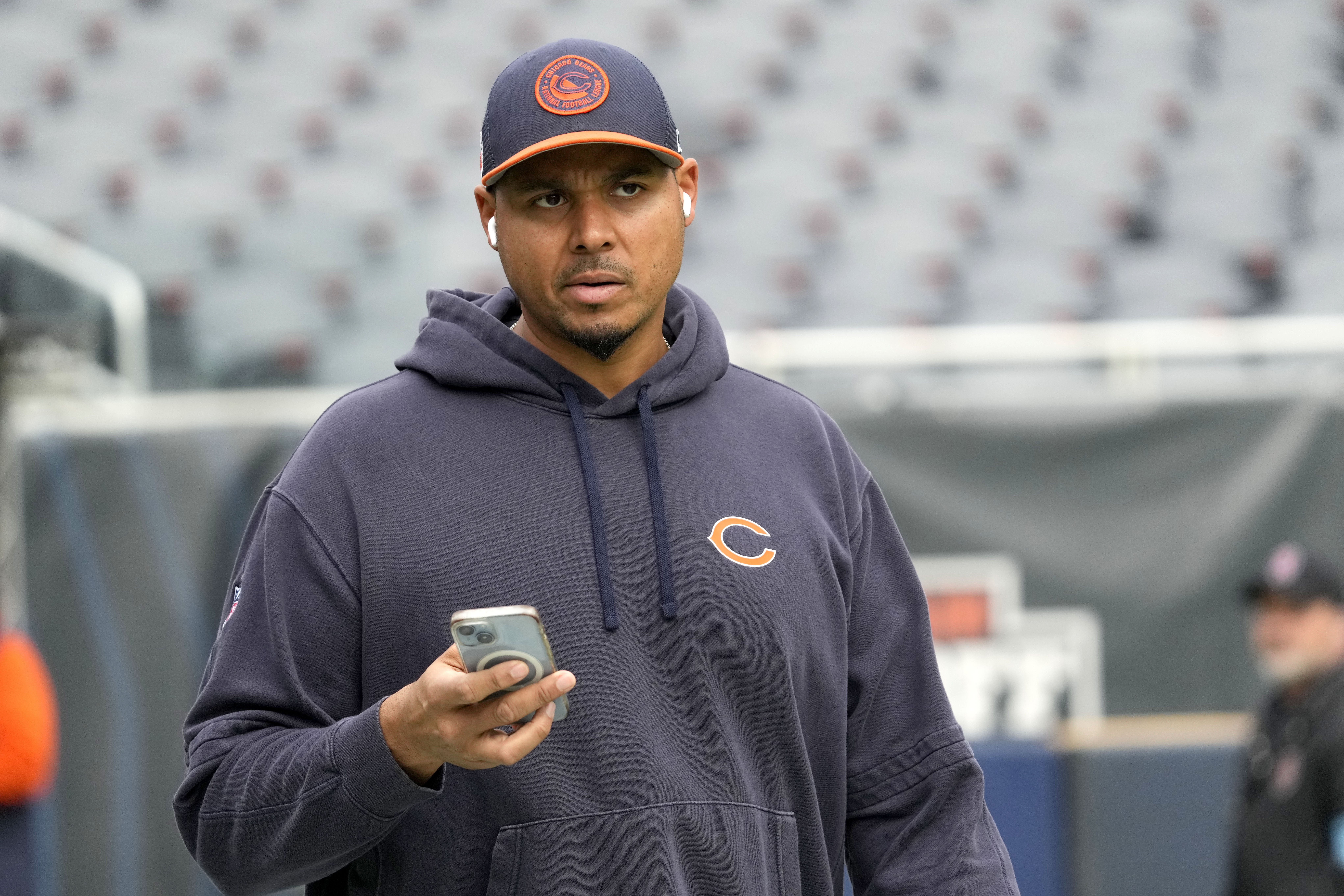 Chicago Bears General Manager Ryan Poles looks up from his cellphone as he walks the field before an NFL football game against the New England Patriots on Sunday, Nov. 10, 2024, in Chicago.