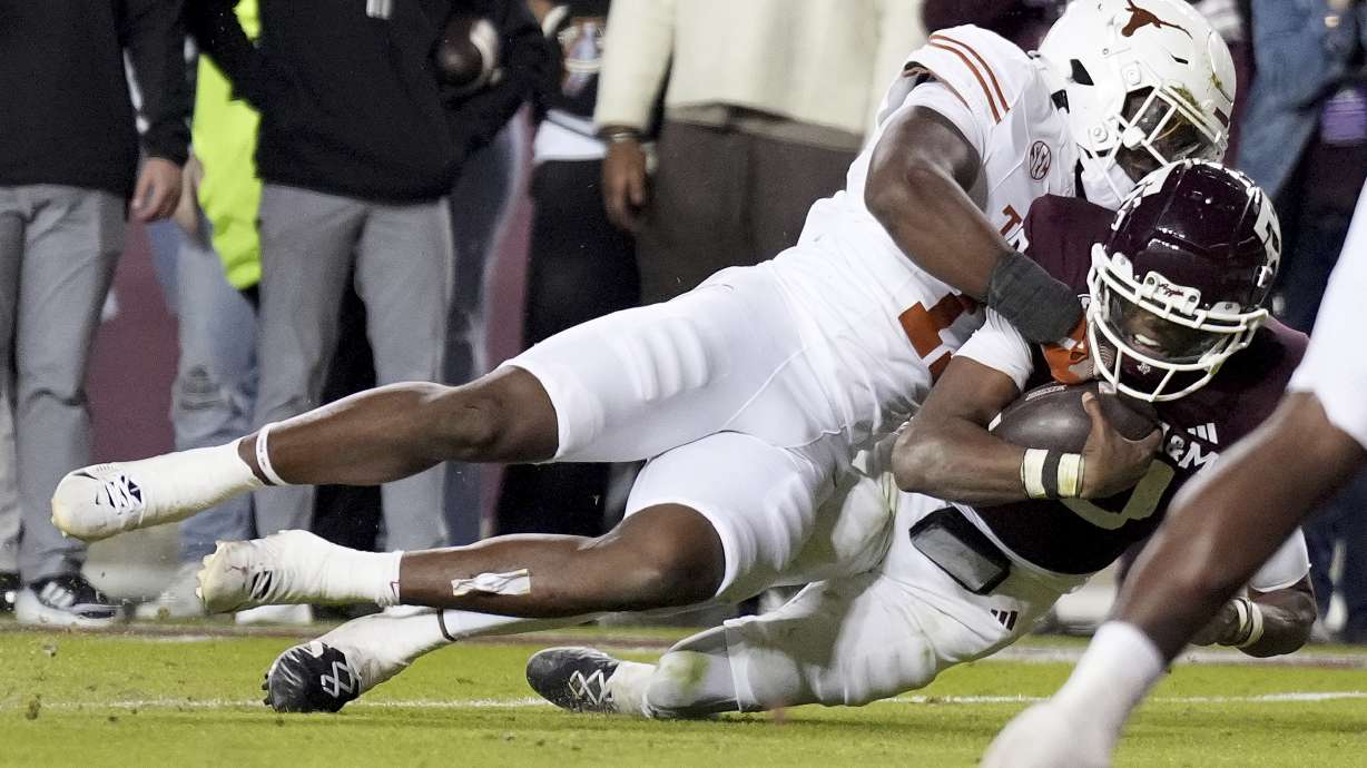 Texas linebacker Colin Simmons, top, tackles Texas A&M quarterback Marcel Reed, bottom, short of the goal line during the second half of an NCAA college football game Saturday, Nov. 30, 2024, in College Station, Texas.