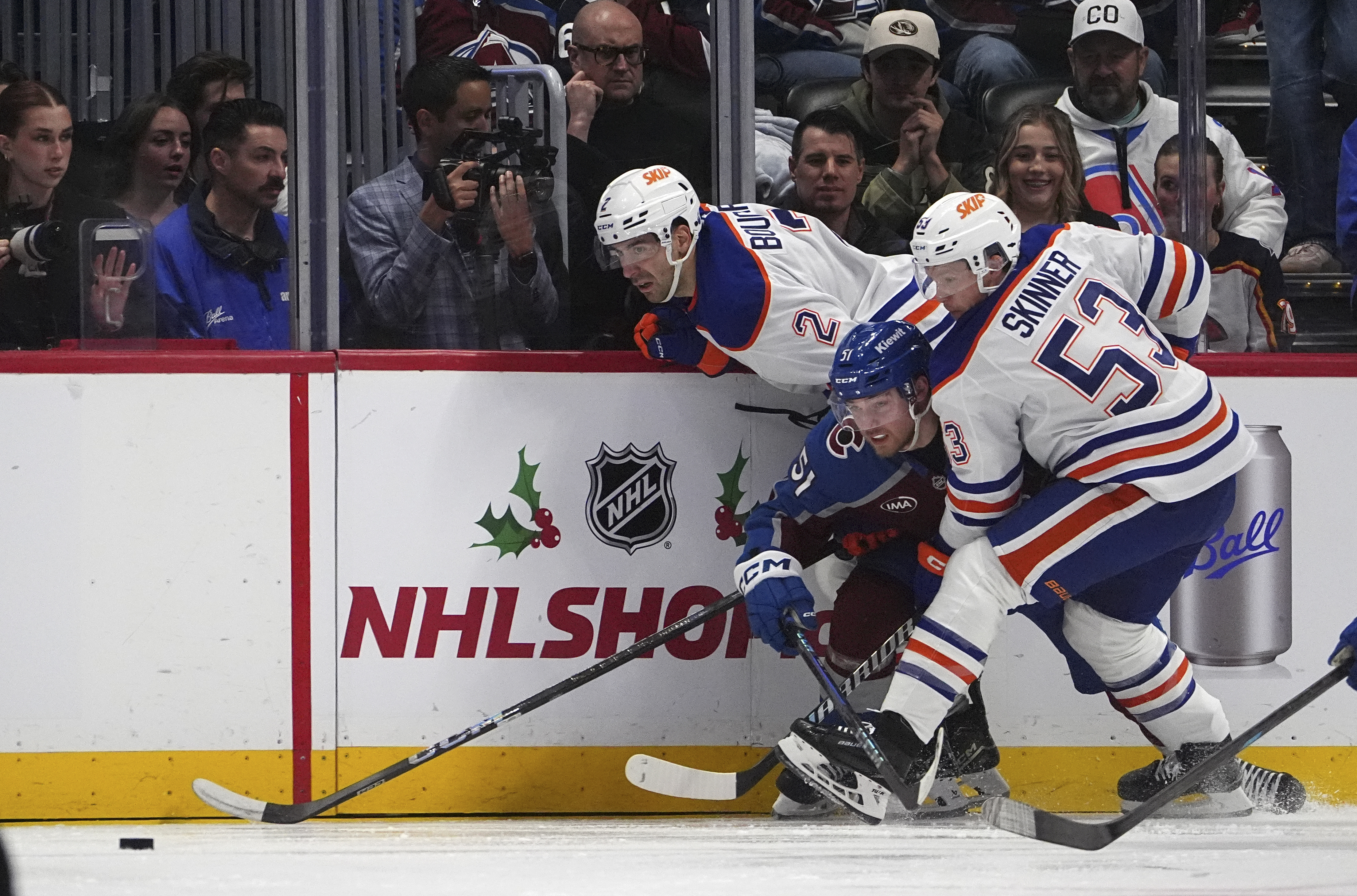 Colorado Avalanche right wing Nikolai Kovalenko, center, is trapped by Edmonton Oilers center Jeff Skinner, front, and defenseman Evan Bouchard while pursuing the puck in the second period of an NHL hockey game Saturday, Nov. 30, 2024, in Denver.
