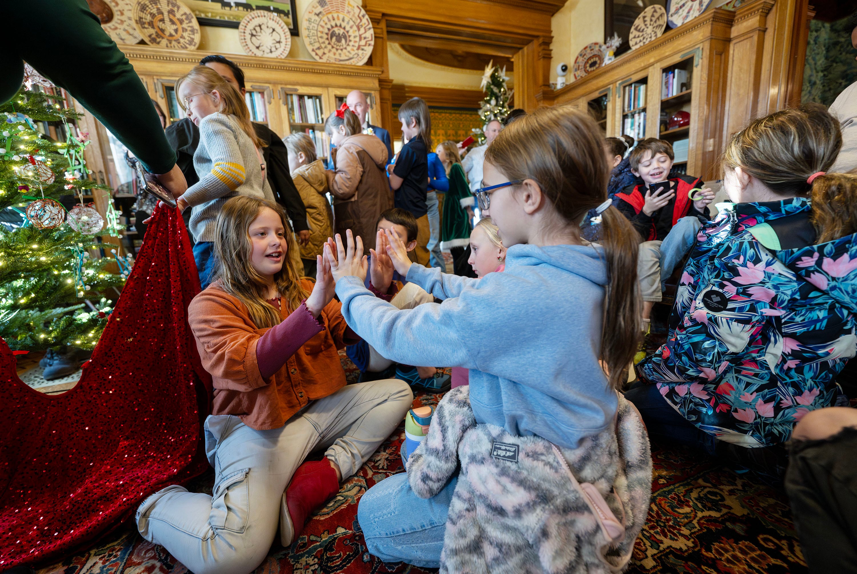 Abby Pappas and Nyah Johnson play as they and other kids help to decorate a Christmas tree as Gov. Spencer Cox and first lady Abby Cox welcome kids from Polk Elementary in Ogden into the Governor's Mansion in Salt Lake City on Monday.