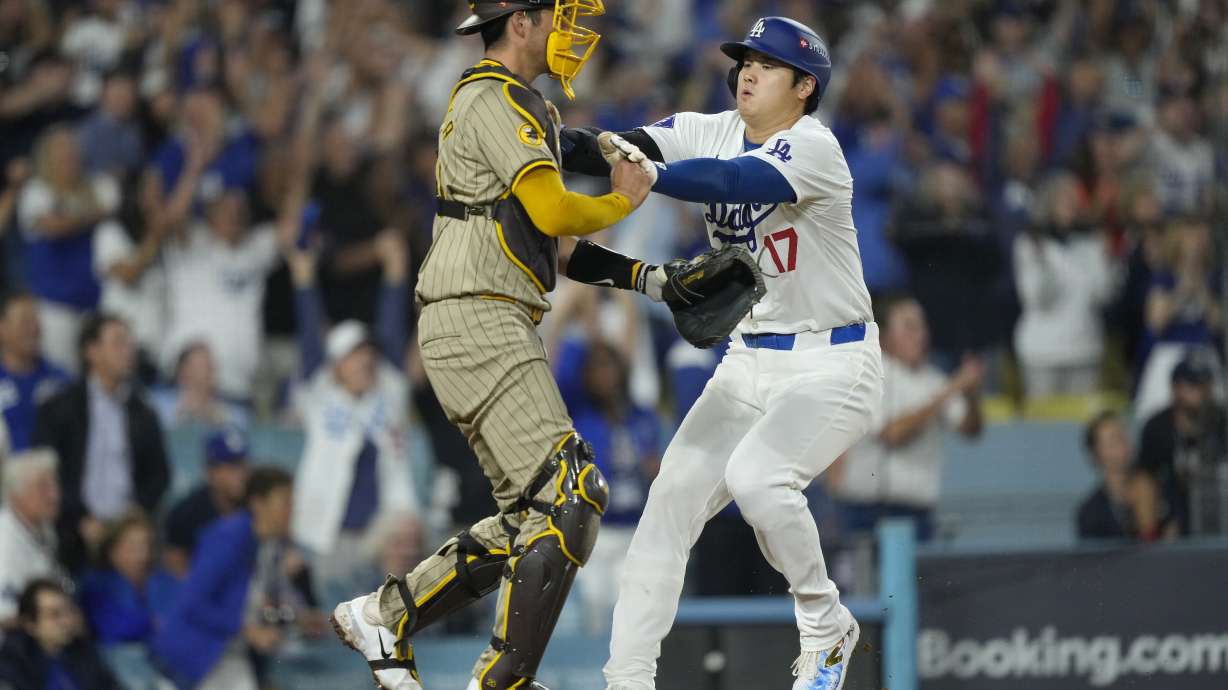 FILE - Los Angeles Dodgers' Shohei Ohtani, right, collides with San Diego Padres catcher Kyle Higashioka as he scores on a single by Teoscar Hernández during the fourth inning in Game 1 of baseball's NL Division Series, on Oct. 5, 2024, in Los Angeles.