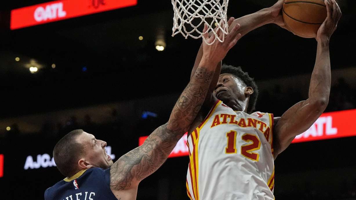 Atlanta Hawks forward De'Andre Hunter (12) grabs a rebound from New Orleans Pelicans center Daniel Theis (10) during the first half of an NBA basketball game, Monday, Dec. 2, 2024, in Atlanta.