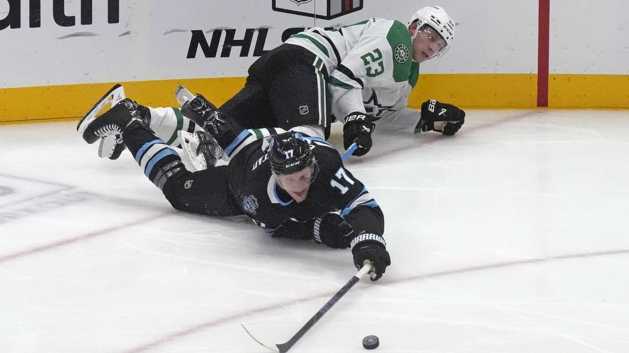 Dallas Stars defenseman Esa Lindell (23) and Utah Hockey Club center Nick Bjugstad (17) battle for the puck during the second period of an NHL hockey game Monday, Dec. 2, 2024, in Salt Lake City.