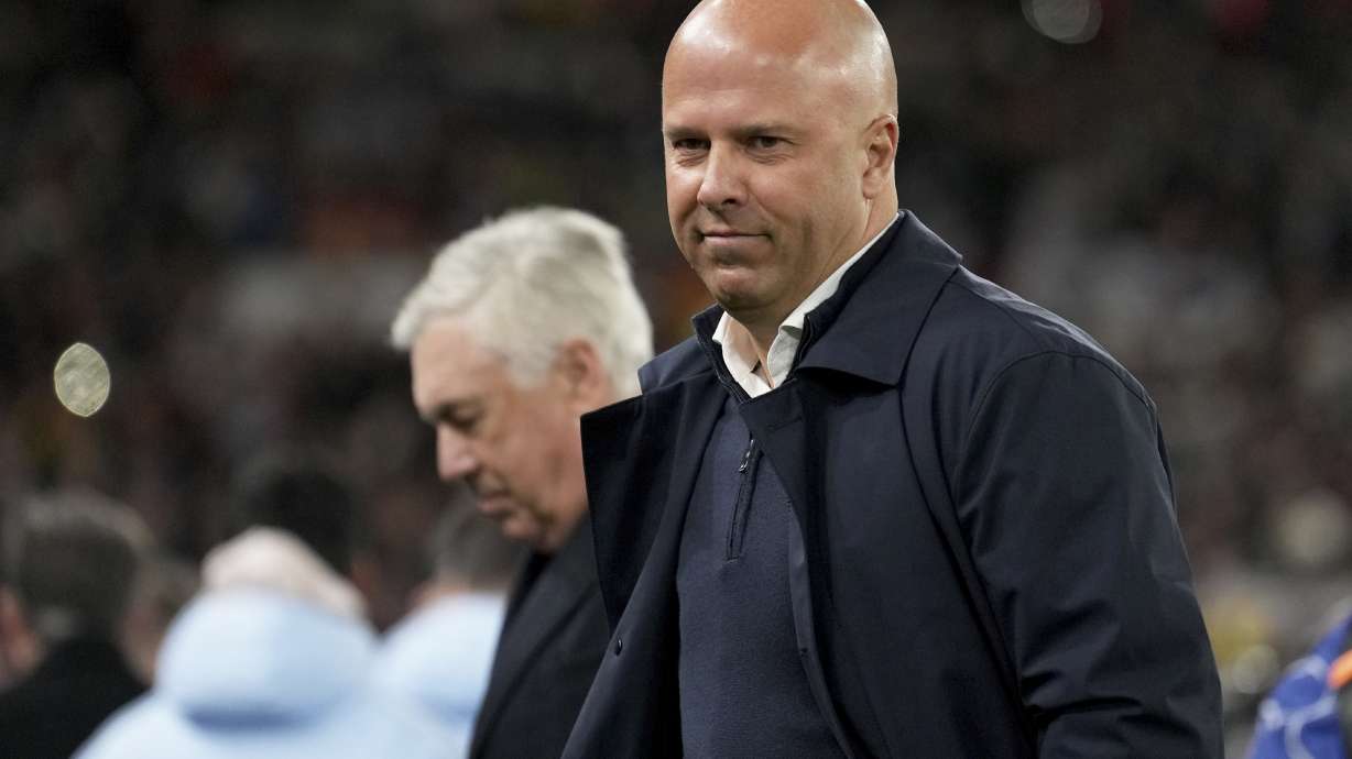 Liverpool's manager Arne Slot and Real Madrid's head coach Carlo Ancelotti, in the background, stand by the touchline before the Champions League opening phase soccer match between Liverpool and Real Madrid at Anfield Stadium, Liverpool, England, Wednesday, Nov. 27, 2024.