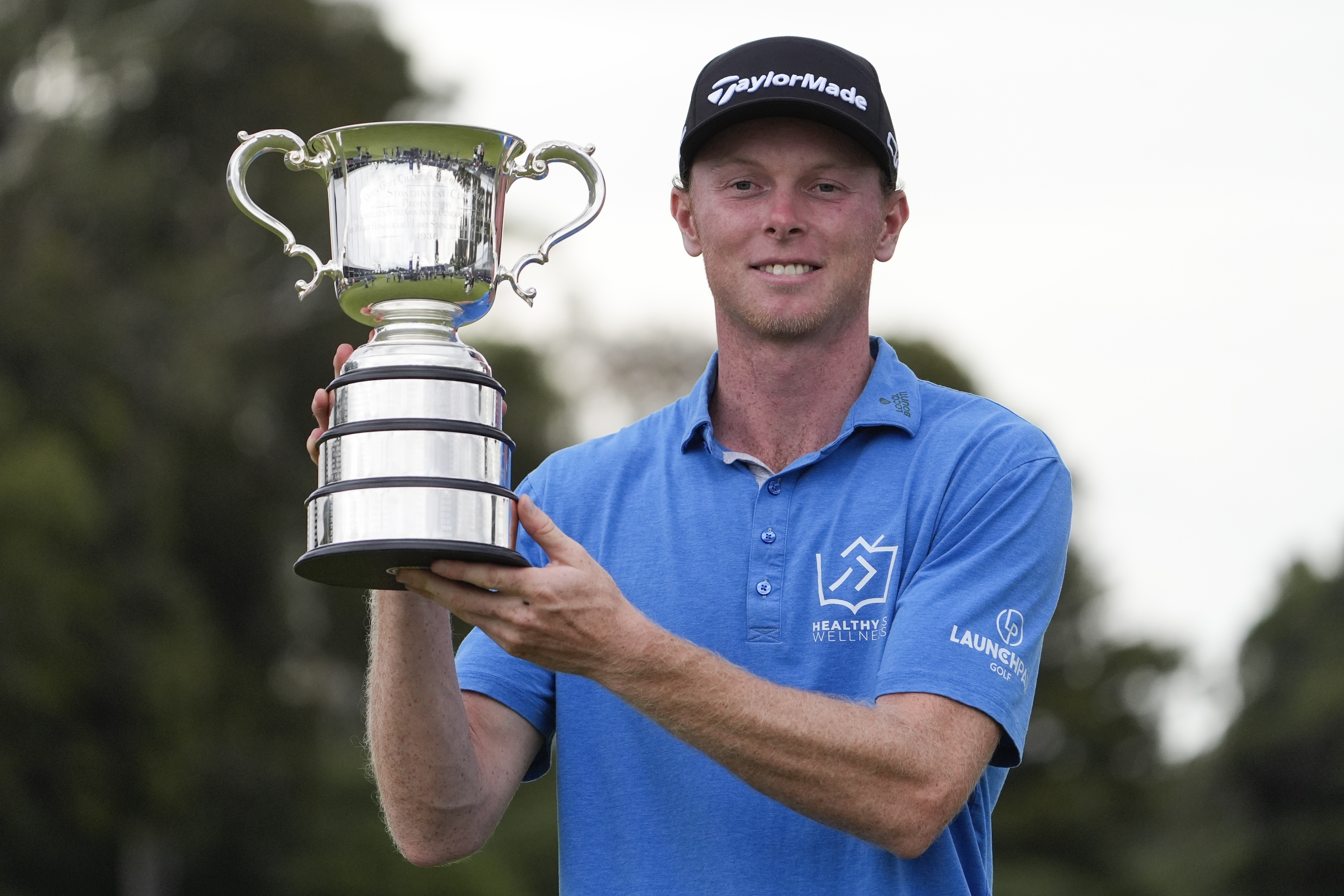 Ryggs Johnston of the United States holds the Stonehaven Cup after winning the Australian Open golf championship at the Kingston Heath Golf Club in Melbourne, Australia, Sunday, Dec. 1, 2024.