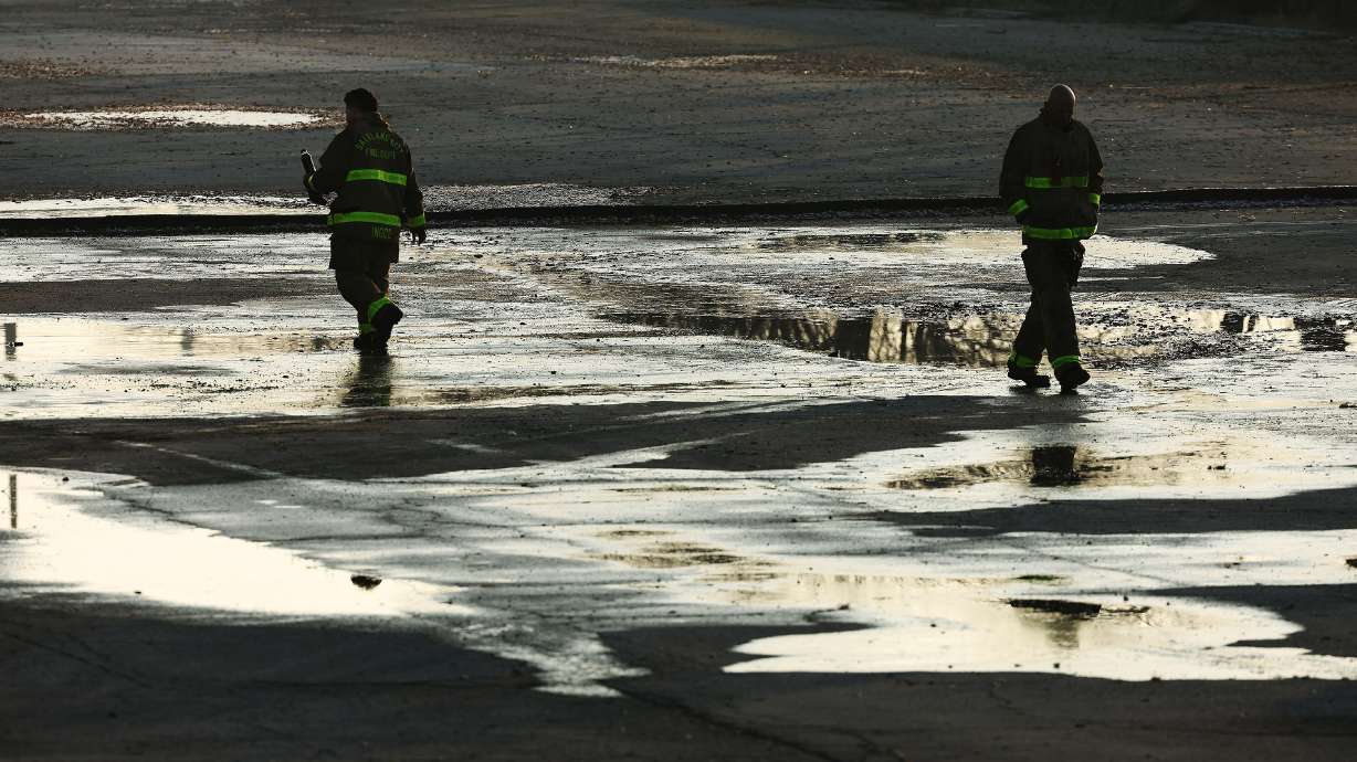 Salt Lake City firefighters walk near a structure fire on Temple Temple in Salt Lake City on Tuesday.