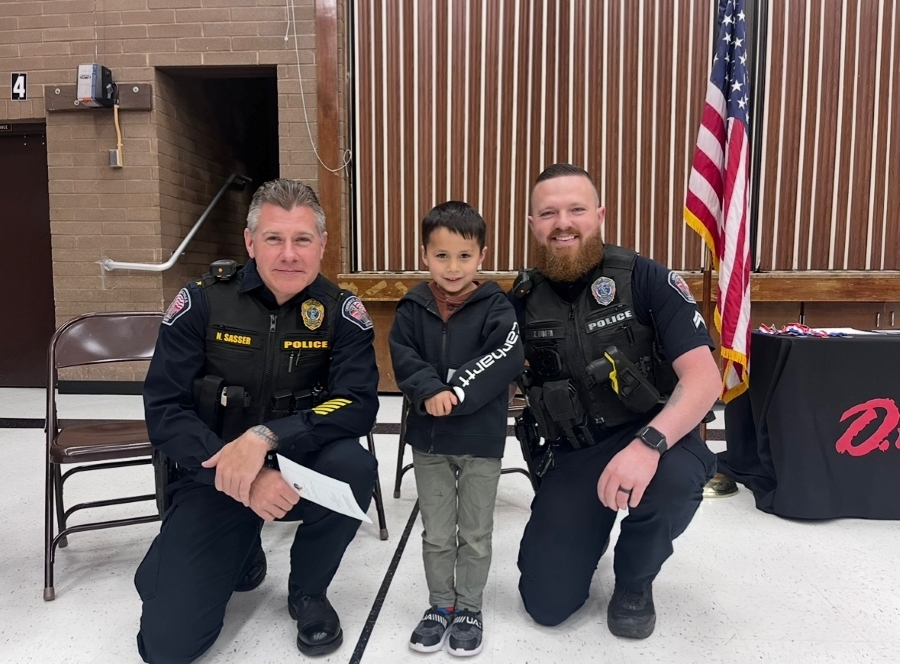 River Elquezabal, center, meets Chubbuck Police Chief Nick Sasser, left, and Sgt. Tyler Hoffa at a DARE graduation at Ellis Elementary in Chubbuck, Idaho in this undated photo. River and the officers are featured in a viral TikTok video.