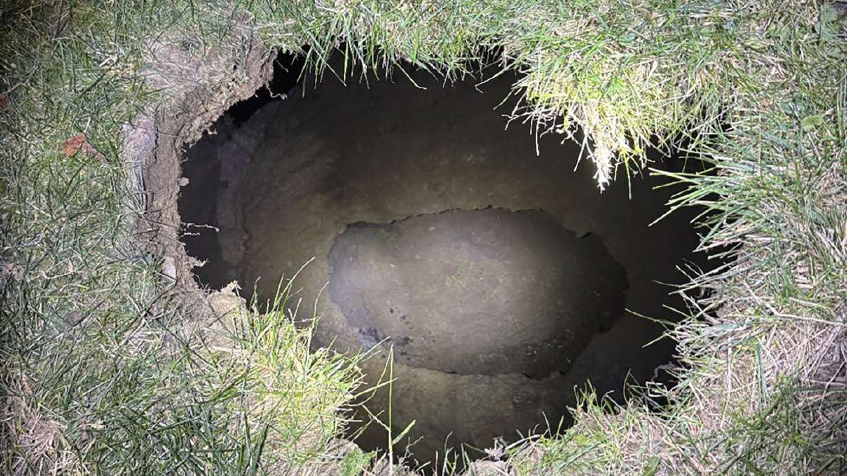 This Tuesday image shows the top of a sinkhole in the village of Marguerite, Pa., where rescuers were searching for a woman who disappeared.