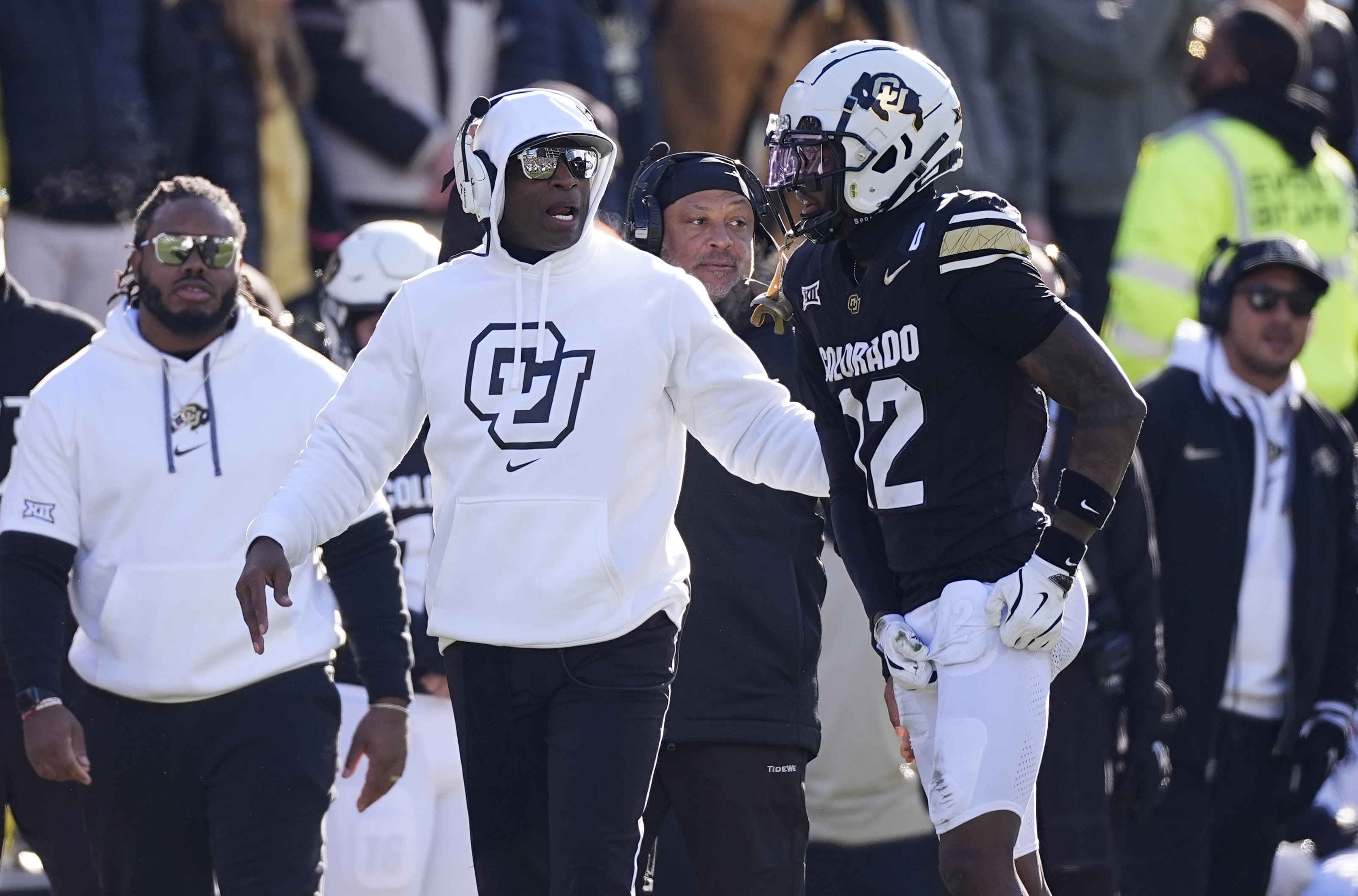 Colorado head coach Deion Sanders, left, confers with wide receiver Travis Hunter in the first half of an NCAA college football game against Oklahoma State Friday, Nov. 29, 2024, in Boulder, Colo.