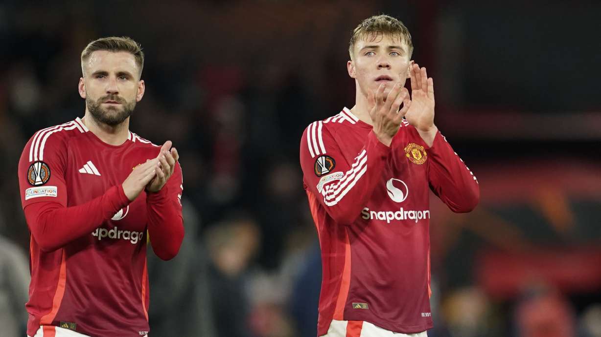 Manchester United's Luke Shaw, left, and Manchester United's Rasmus Hojlund greet fans at the end of the Europa League opening phase soccer match between Manchester United and Bodo Glimt, at the Old Trafford stadium in Manchester, England, Thursday, Nov. 28, 2024.