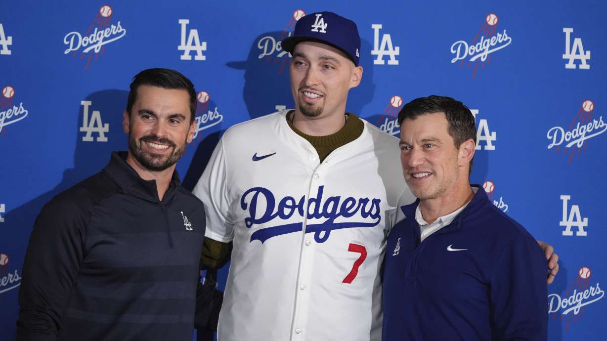 Los Angeles Dodgers pitcher Blake Snell, center, poses for photos with president of baseball operations Andrew Friedman, right, and general manager Brandon Gomes during a news conference Tuesday, Dec. 3, 2024, in Los Angeles.