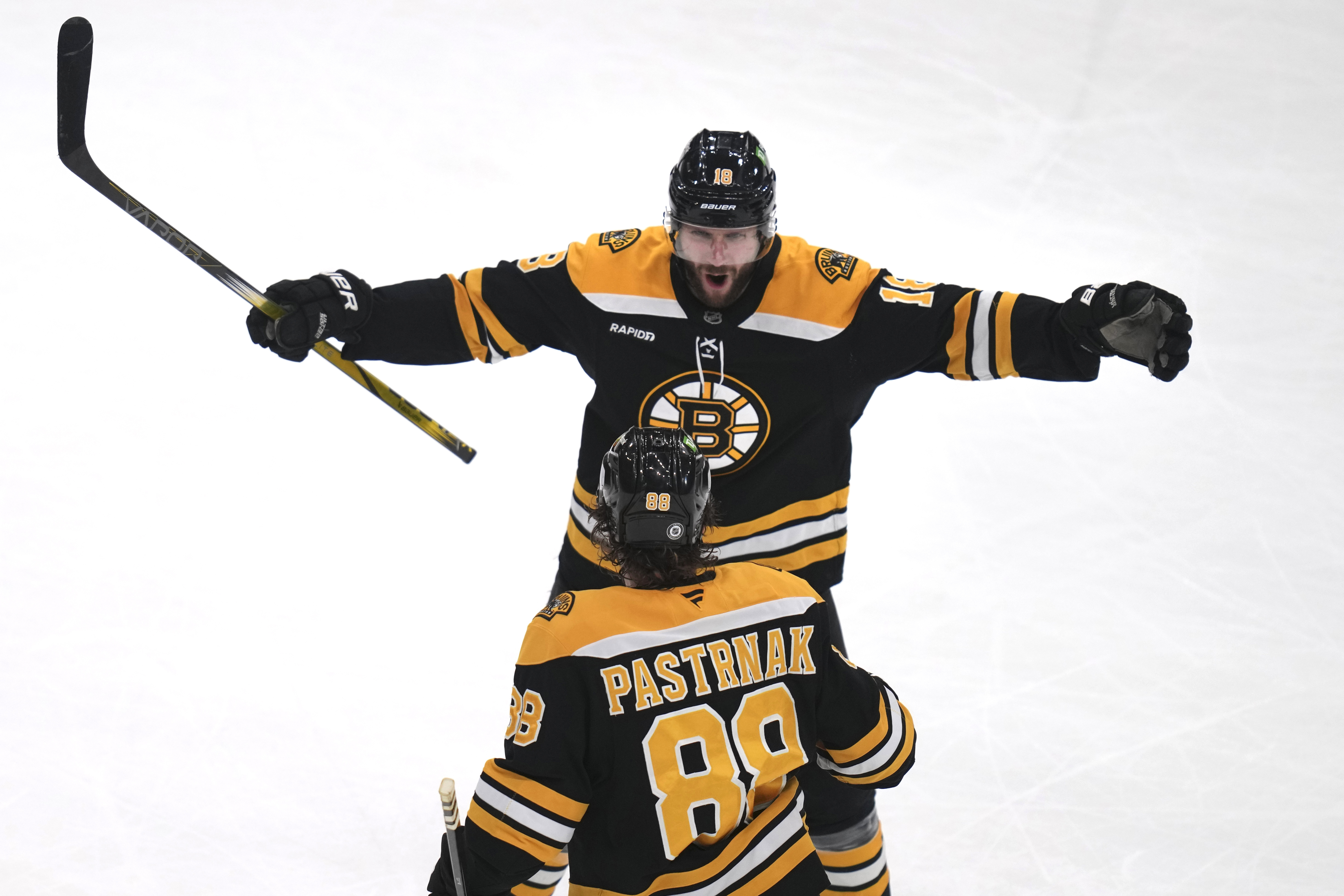 Boston Bruins center Pavel Zacha, top, celebrates with David Pastrnak (88) after his game winning goal off Detroit Red Wings goaltender Ville Husso during an overtime period of an NHL hockey game, Tuesday, Dec. 3, 2024, in Boston.