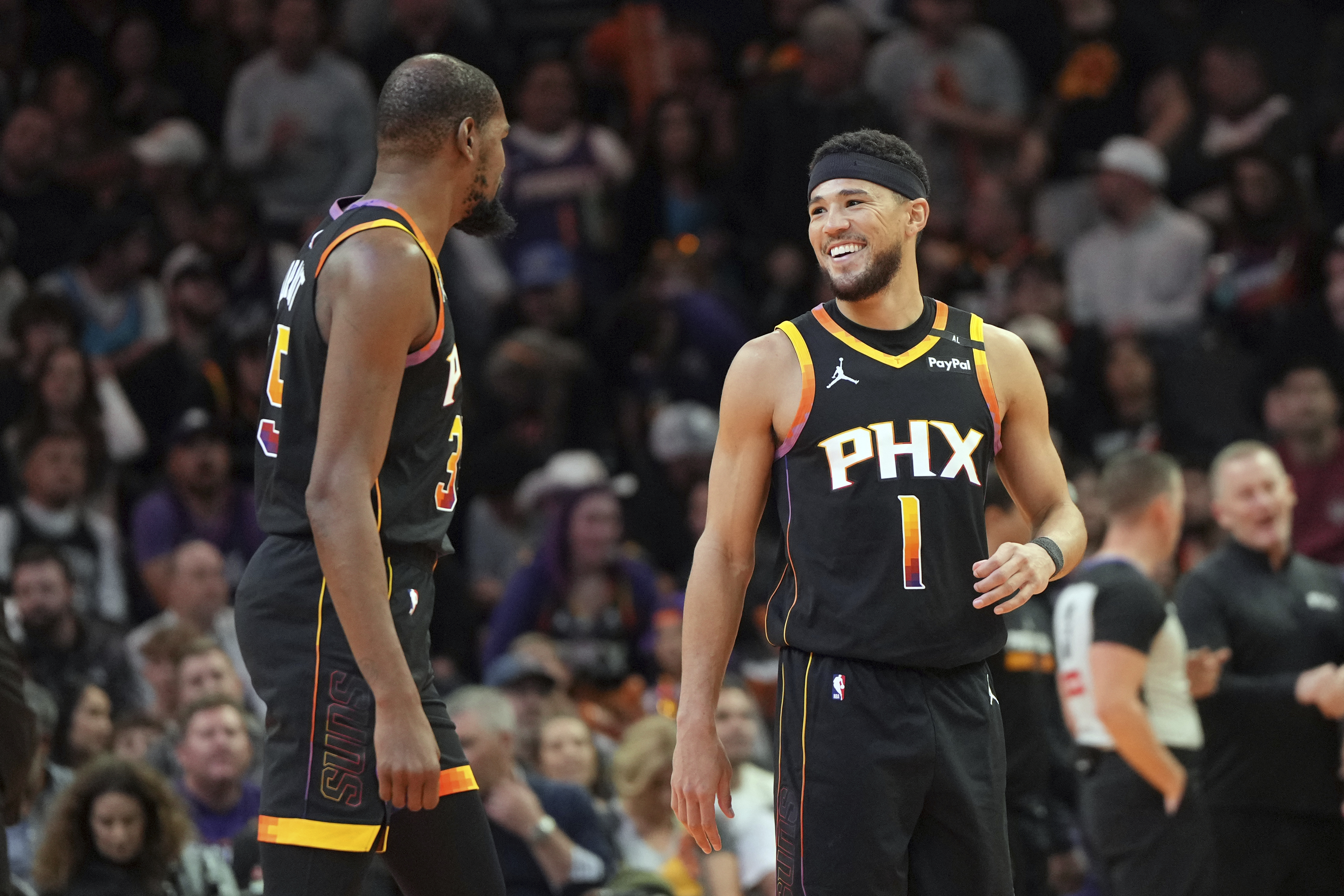 Phoenix Suns guard Devin Booker (1) reacts with forward Kevin Durant after scoring his 1500th career point against the San Antonio Spurs during the first half of an NBA basketball game, Tuesday, Dec. 3, 2024, in Phoenix.