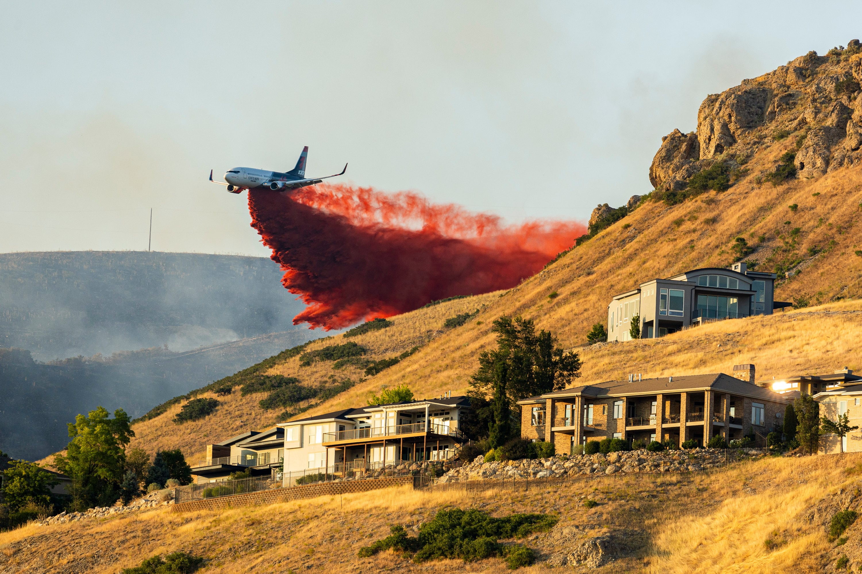 A plane drops fire retardant as the Sandhurst Fire burns above Ensign Peak north of Salt Lake City on July 20. Sen. Mitt Romney says drought and wildfire work are among his top accomplishments in office.