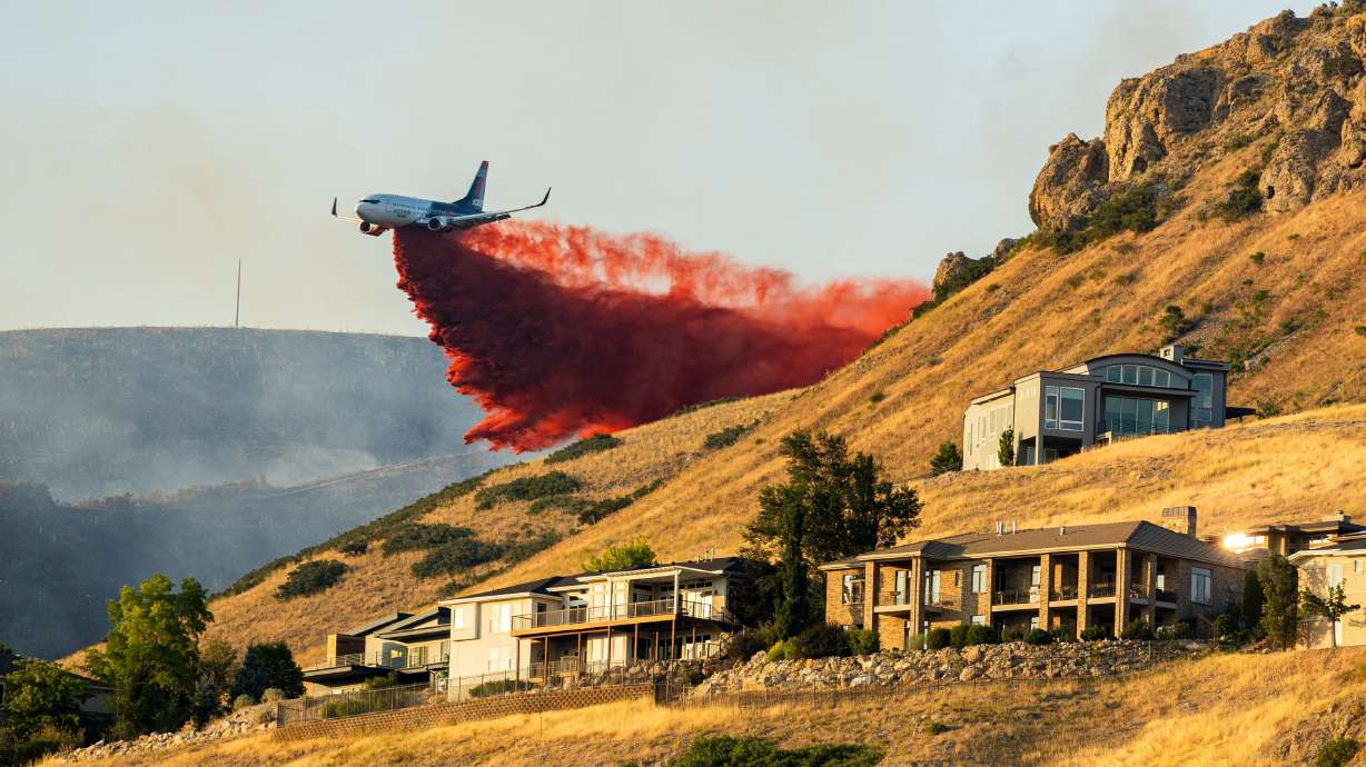 A plane drops fire retardant as the Sandhurst Fire burns above Ensign Peak north of Salt Lake City on July 20. Sen. Mitt Romney says drought and wildfire work are among his top accomplishments in office.