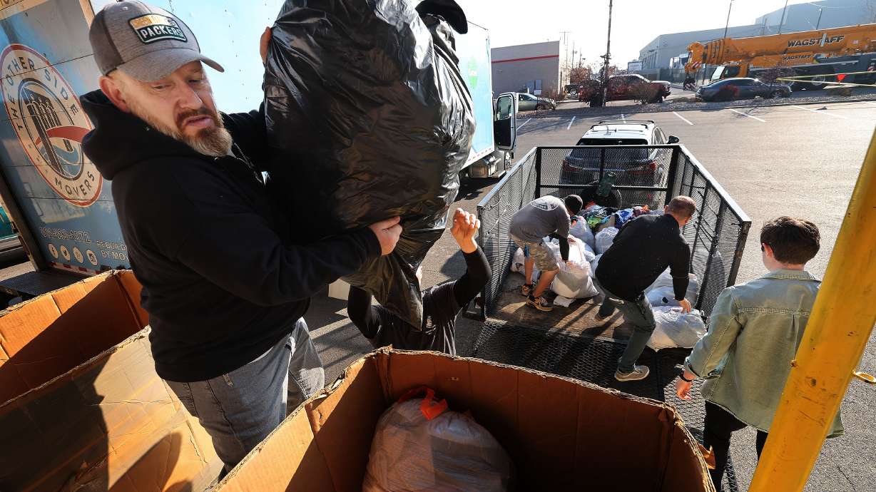 Troy Calton, former student at the Other Side Academy and now employee, helps unload donations as North Star collaborates with Other Side Academy with a clothing drive in Murray on Tuesday.