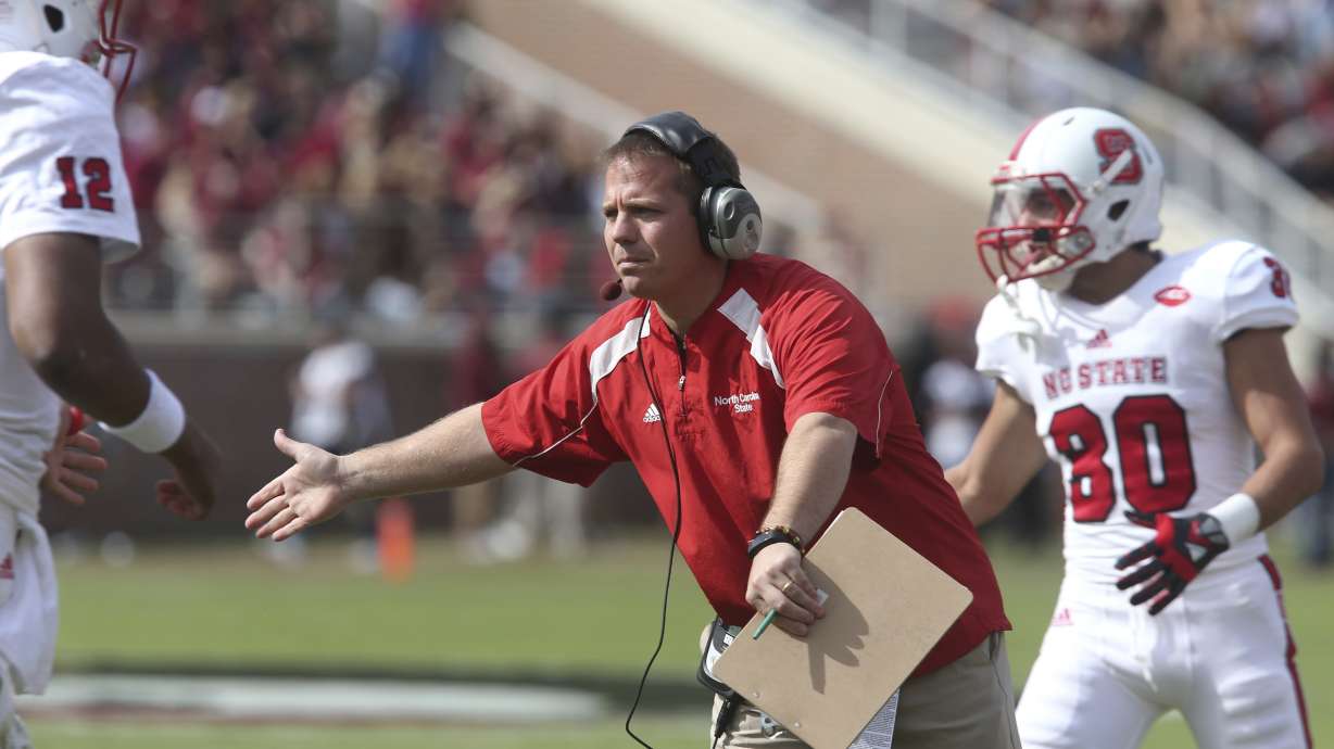 North Carolina State's offensive line coach Mike Uremovich congratulates players as they return to the bench after scoring a touchdown against Florida State in an NCAA college football game, Saturday, Nov. 14, 2015 in Tallahassee, Fla.