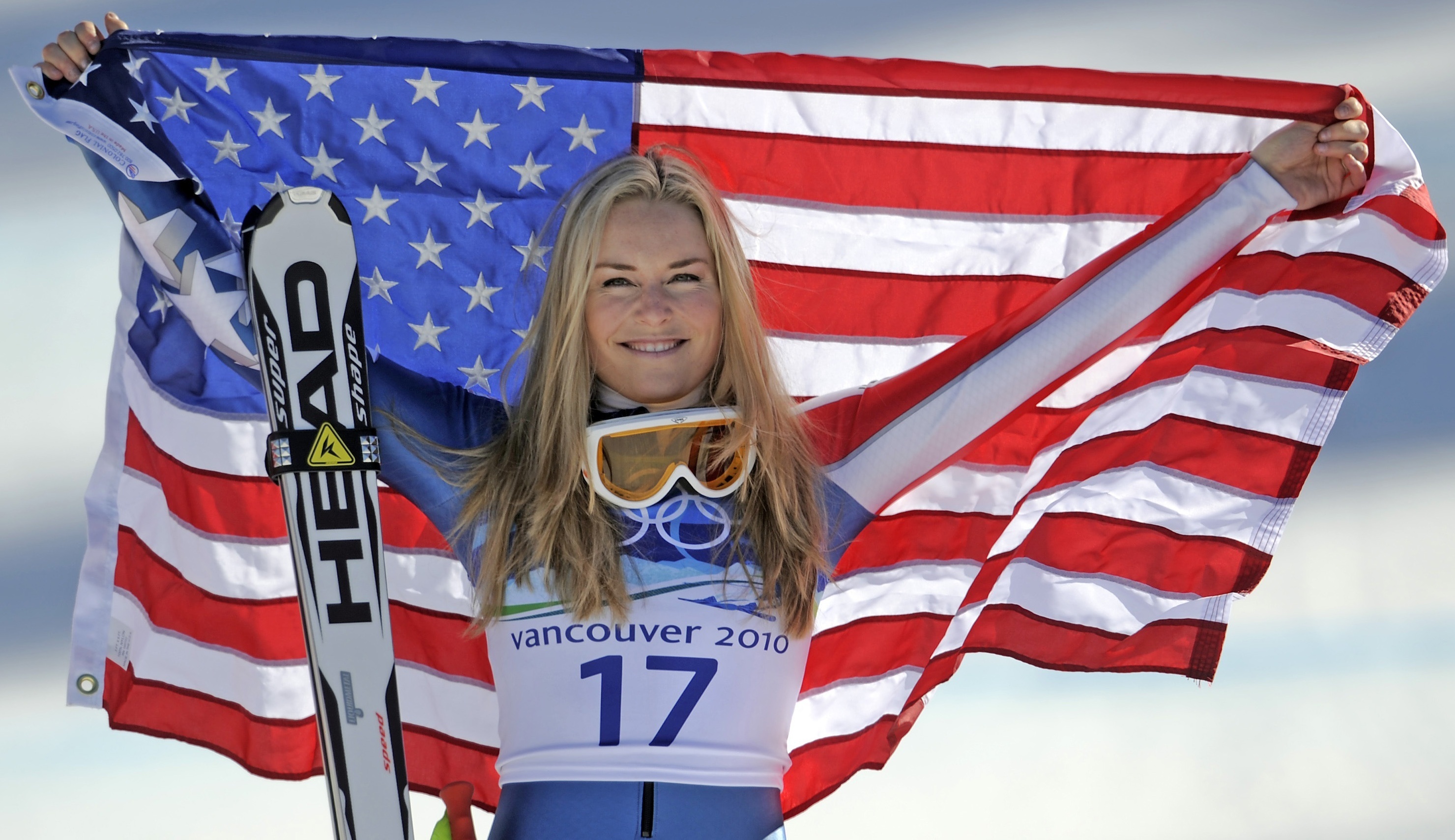 FILE - Bronze medalist Lindsey Vonn of the United States hold the Stars and Stripes during the flower ceremony for the Women's super-G at the Vancouver 2010 Olympics in Whistler, British Columbia, Feb. 20, 2010.