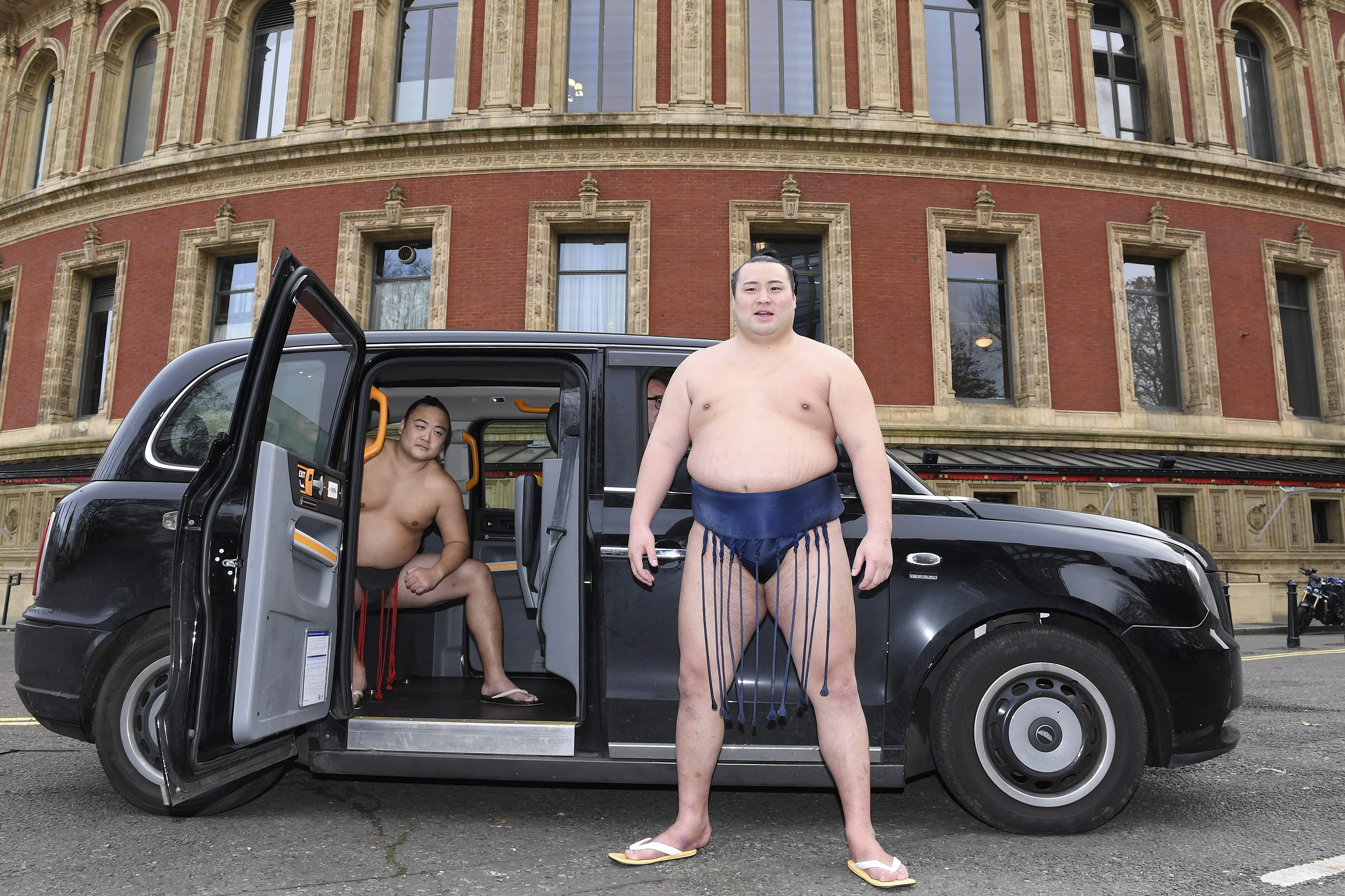 Rishikis from Japan's Sumo Kyokai, Daisuke Kitanowaka, right, and Akira Fukutsuumi pose for a photo call outside of London's Royal Albert Hall in London, Wednesday, Dec. 4, 2024 where the UK's second ever official basho will take place in October of next year.