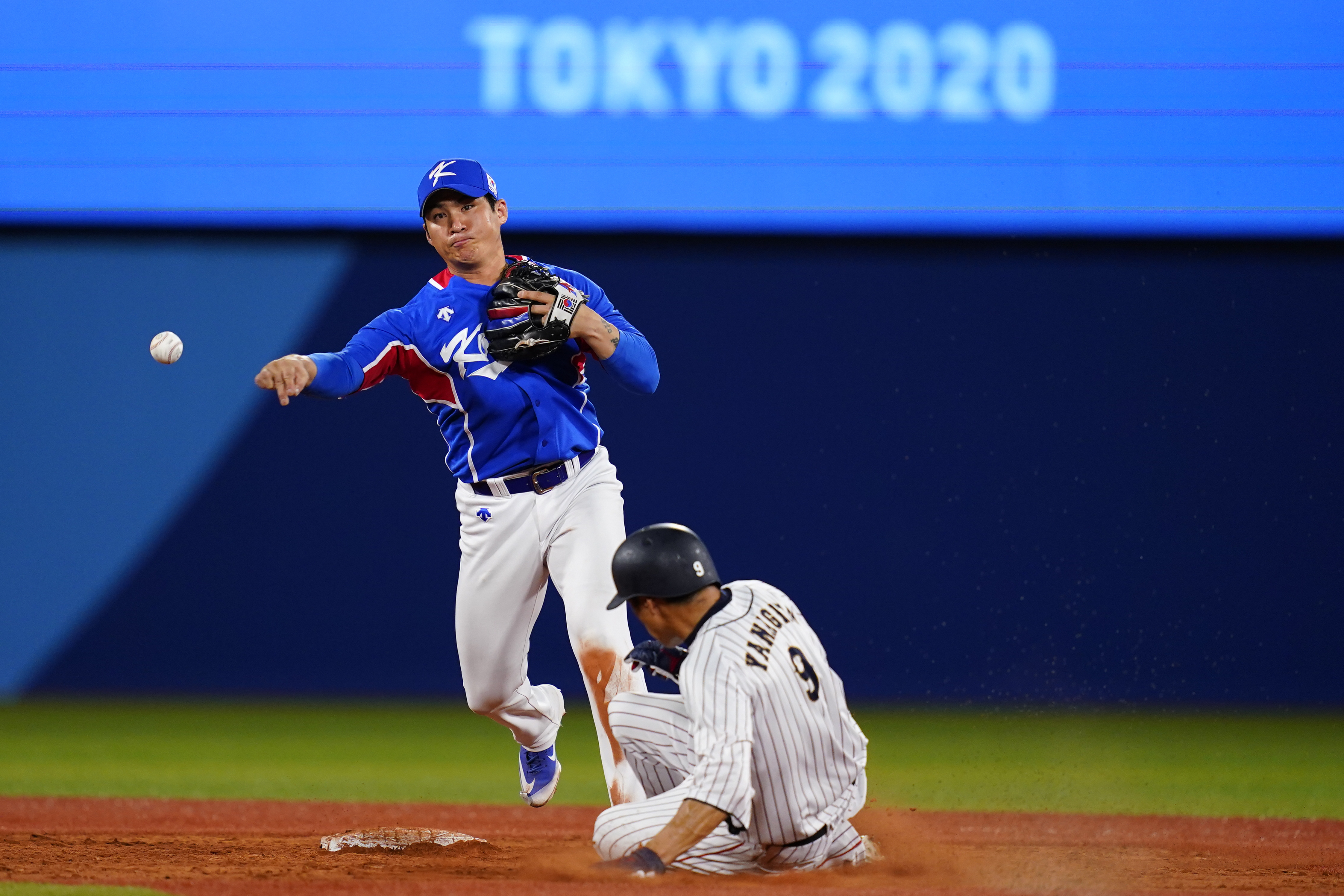 FILE - South Korea's Hyeseong Kim throws to first after forcing out Japan's Yuki Yanagita during a semi-final baseball game at the 2020 Summer Olympics, Wednesday, Aug. 4, 2021, in Yokohama, Japan.