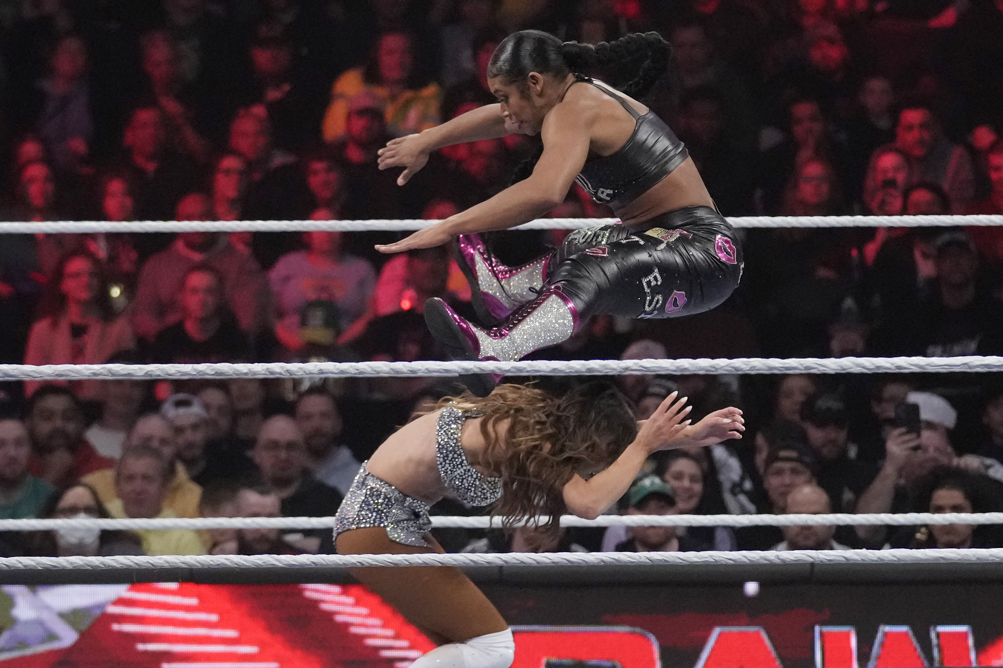 FILE - Wrestler Bianca Belair, top, leaps over Carmella during the WWE Monday Night RAW event, on March 6, 2023, in Boston.