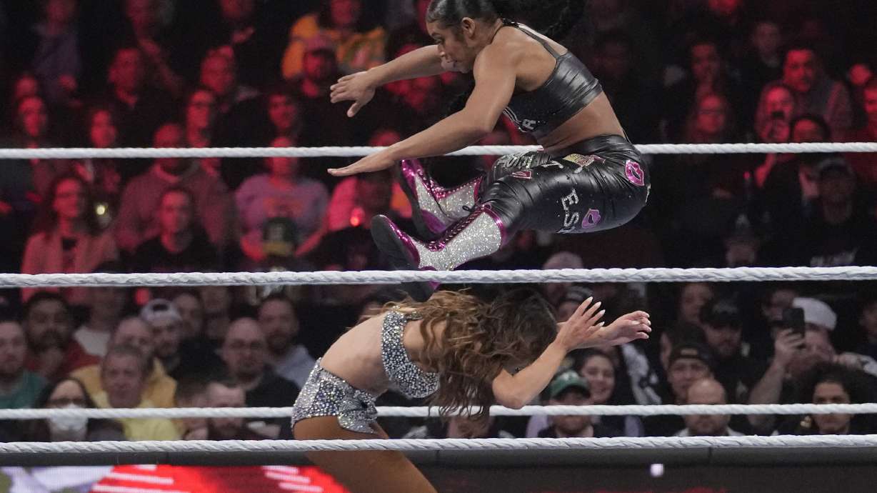 Wrestler Bianca Belair, top, leaps over Carmella during the WWE Monday Night RAW event, on March 6, 2023, in Boston.